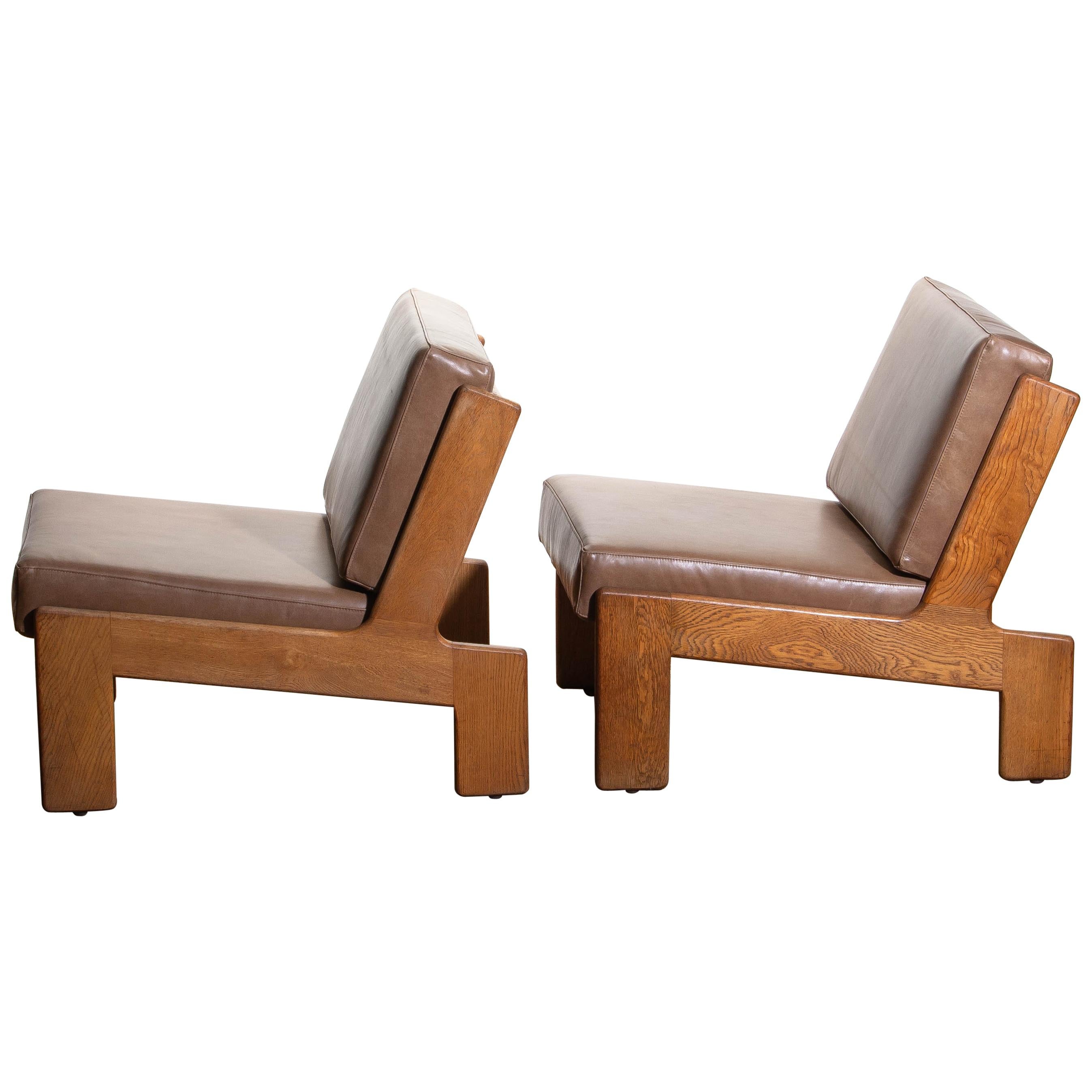 1960s set of two extremely rare cubist lounge /easy chairs designed by Esko Pajamies for Asko Finland in oak and leather.
The cushions of both chairs are newly upholstered with leather. Also the bindings are replaced.
The overall condition of this