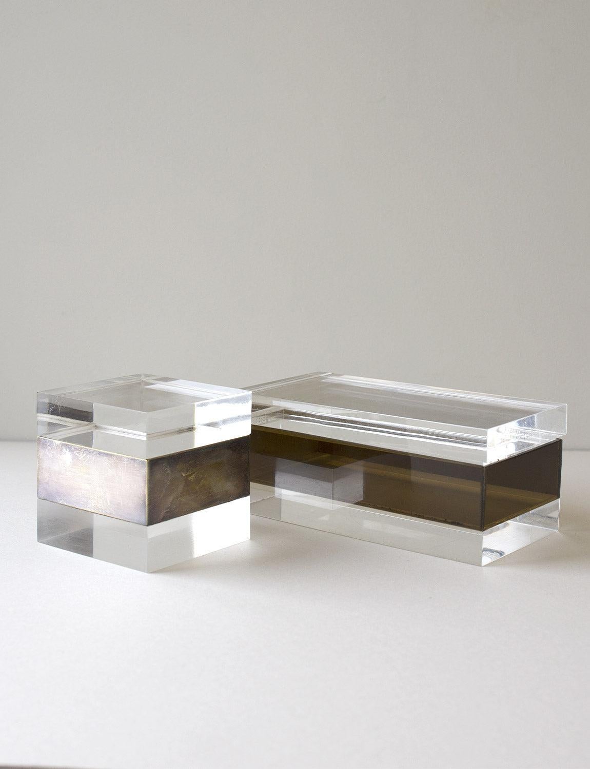Two Italian 1960s/70s plexiglass ornament boxes attributed to Gabriella Crespi the Italian designer. The rectangular box has a thick perspex brown brand and the cube shaped box has a metal band. The pair look extremely chic on a desk or coffee
