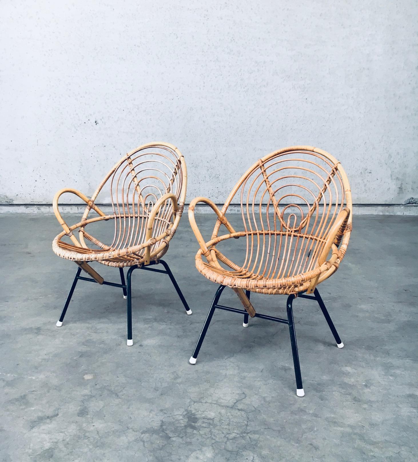 Vintage Midcentury Dutch Design Pair of Rattan / Bamboo Lounge Chairs by Rohe Noordwolde. Made in the Netherlands, Holland, 1950's / 60's period. Bamboo / Rattan construction with black metal base. These armchairs have a nice round pattern in the