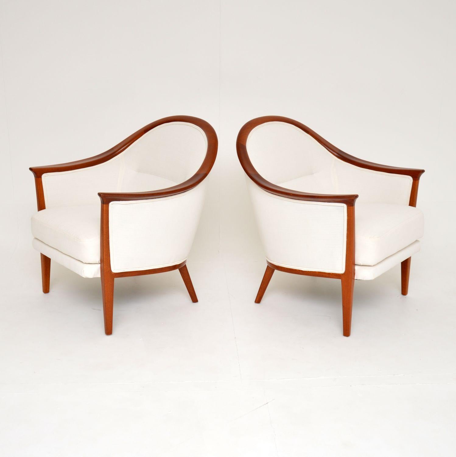 A beautiful pair of vintage Swedish armchairs in solid teak. These were designed by Bertil Fridhagen and made by Bodafors in 1962. The makers stamp and year of production is seen beneath the frames.

They have an absolutely gorgeous design, with