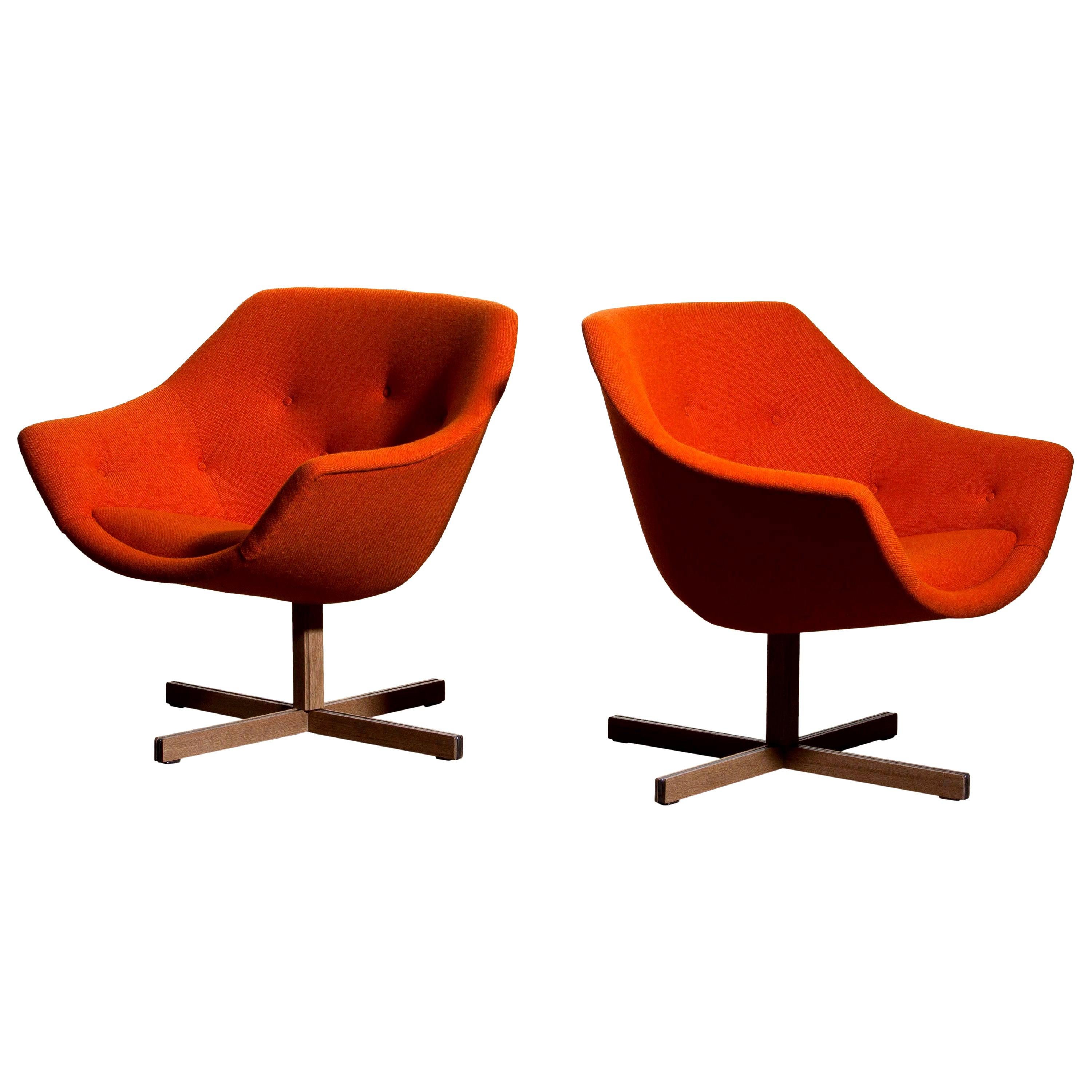 Fantastic pair of 'Mandarini' swivel armchairs made by Carl Gustaf Hiort for Puunveisto Oy, wood work Ltd.
These chairs are upholstered with a buttoned orange fabric 'Hallingdal' by Kvadrat designed by Nanna Ditzel, on an oak swivel base.
They are