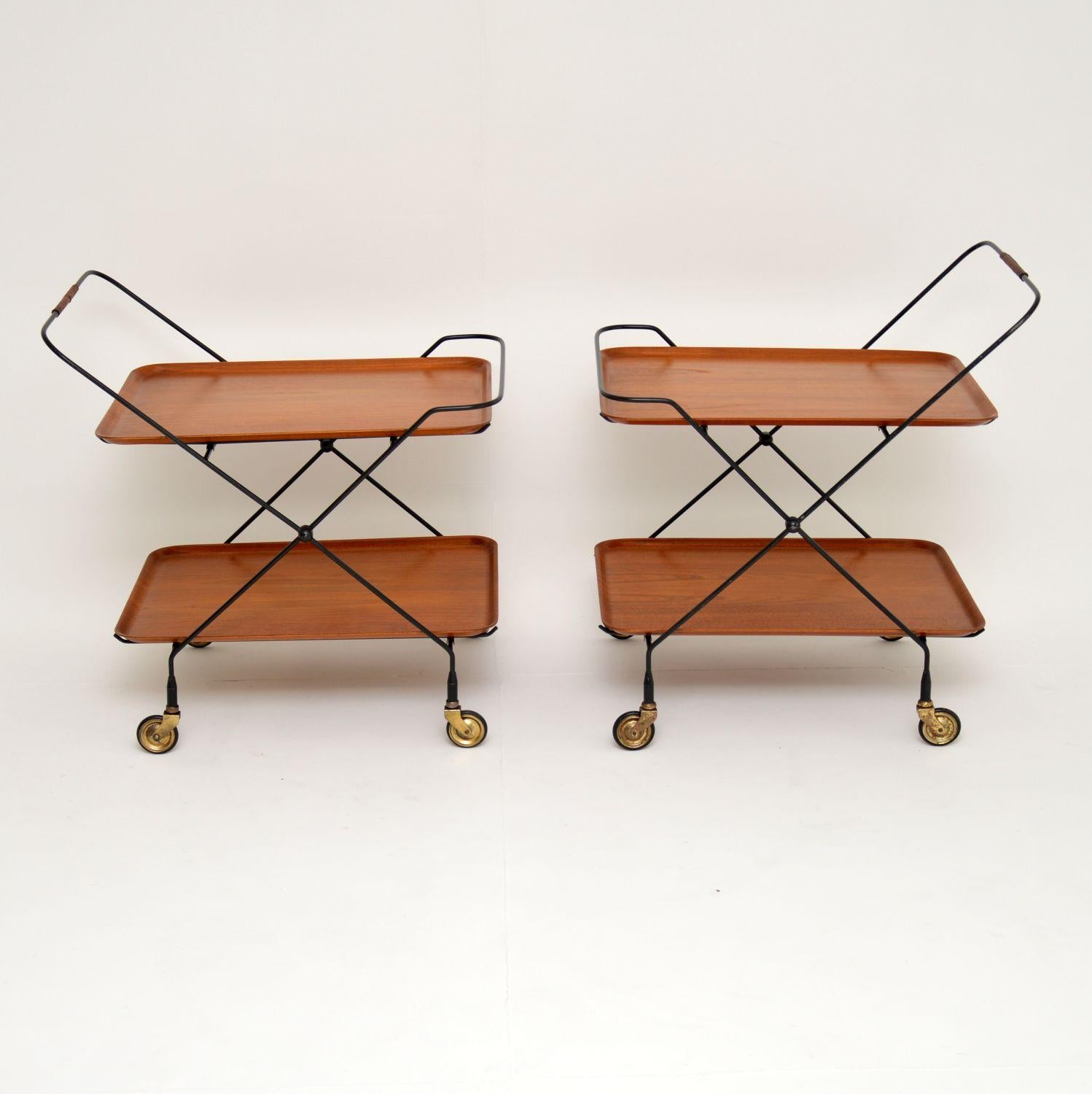 A stunning pair of vintage side tables or serving trolleys, these were made in Sweden and date from the 1960s. They have four loose trays in teak which can all be removed. The trays have all been stripped and re-polished, they are in superb