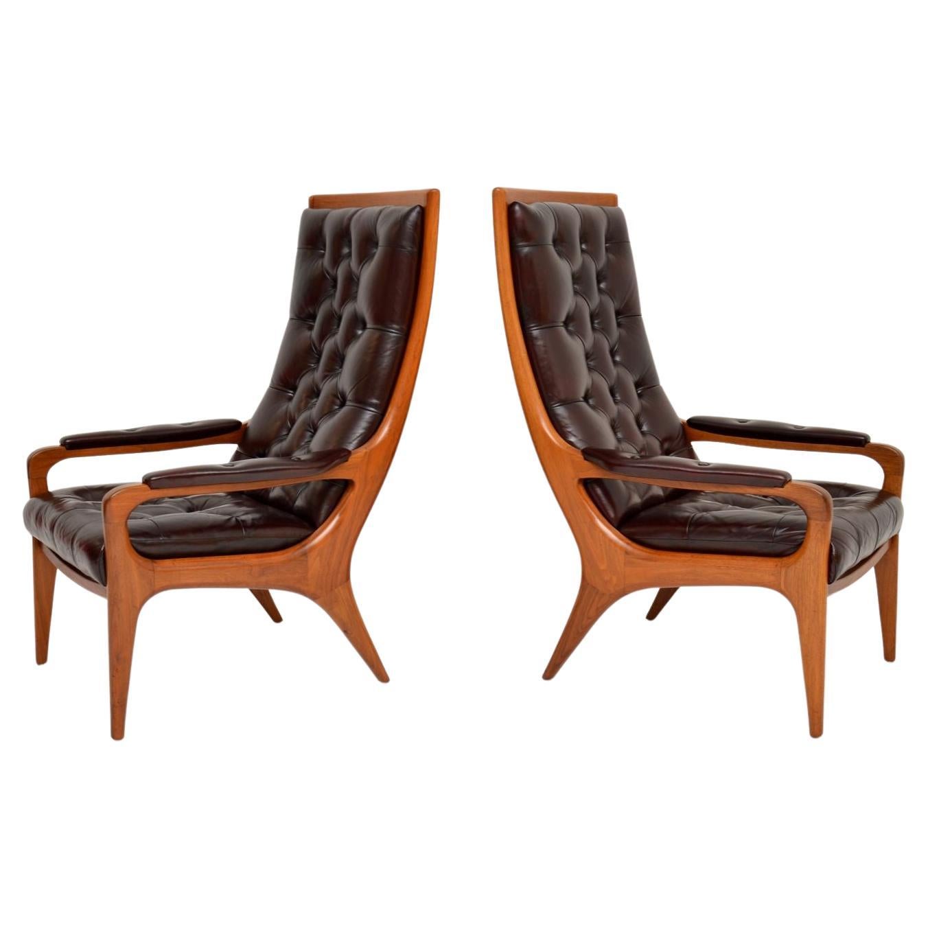 Superbe paire de fauteuils vintage en noyer et cuir de Howard By, datant des années 1960, magnifiquement recouverts d'un profond cuir boutonné. Fabriquées en Angleterre par Howard Keith, elles datent des années 1960.

Ils sont d'une superbe qualité,