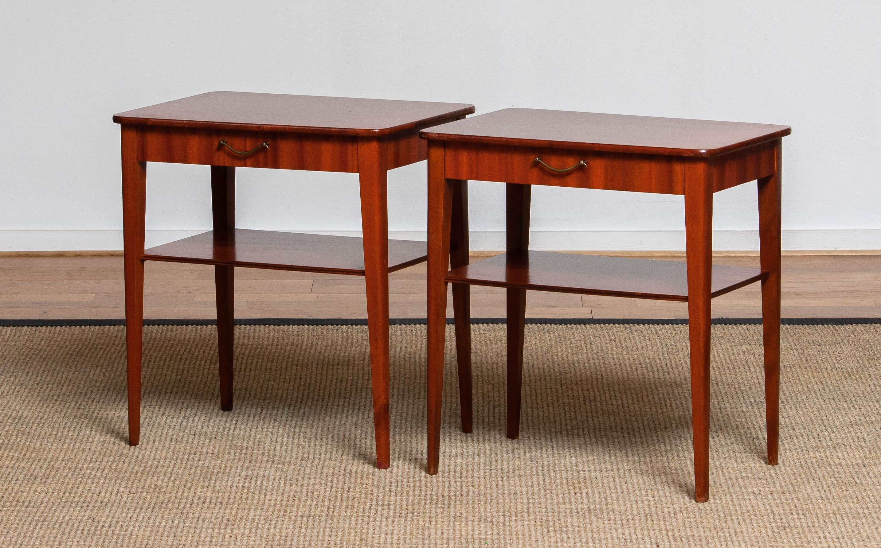 Set of two slim Swedish bedside tables / night stands in mahogany both with a drawer and a shelf. 
Made in the 1960's and in overall good condition.