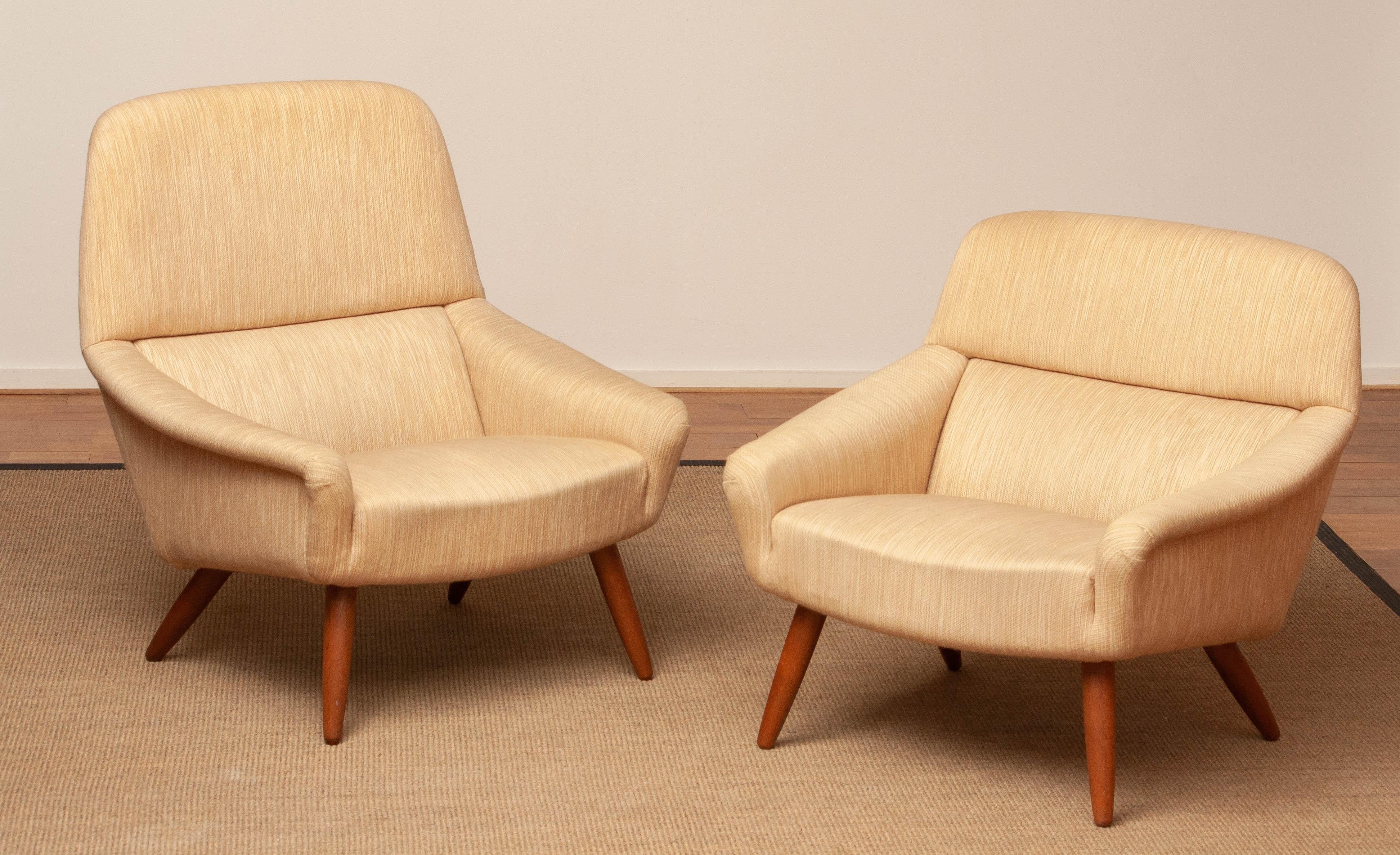 Rare and beautiful pair solid high and low back Scandinavian lounge chairs with the original natural colored woolen fabric and oak legs from the 1960's designed by Leif Hansen for Mobelfabriken Kronen in Denmark.
Both lounge chairs are in overal