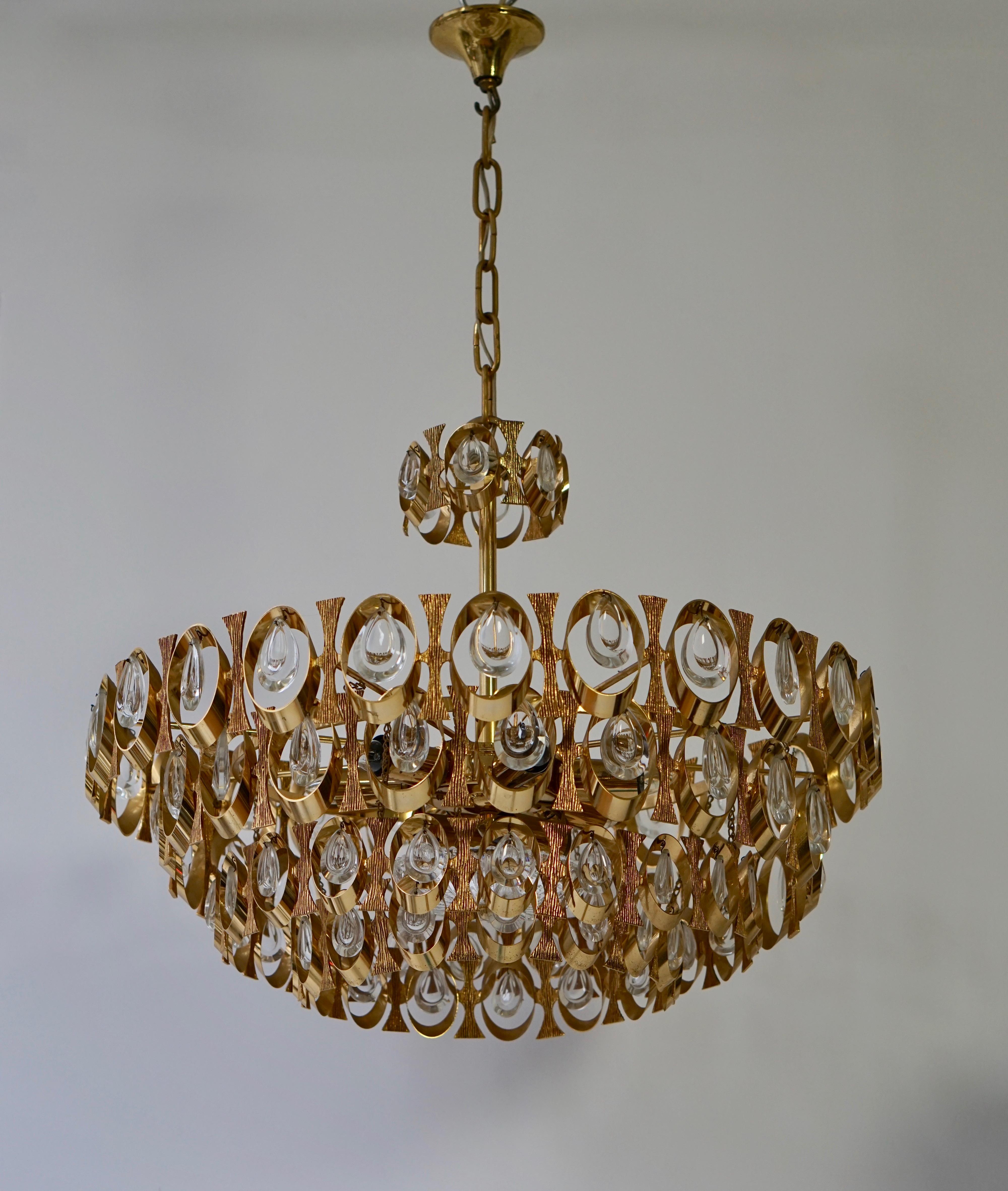 Unique eight-light chandelier with gilt brass beautifully shaped rings and plates. Its truly amazing with all it's crystal prisms excellent condition. By Gaetano Sciolari for Palwa. Please note we have several chandelier in similar style and