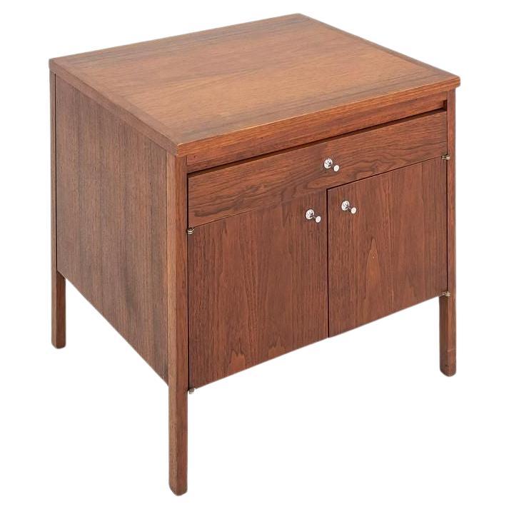 Il s'agit d'une table de nuit ou d'un petit meuble en noyer, conçu par Paul McCobb pour sa série Delinator pour Lane Altavista en 1961. La pièce a été fabriquée à la main aux États-Unis dans les années 1960. Le grain du placage de noyer est exquis