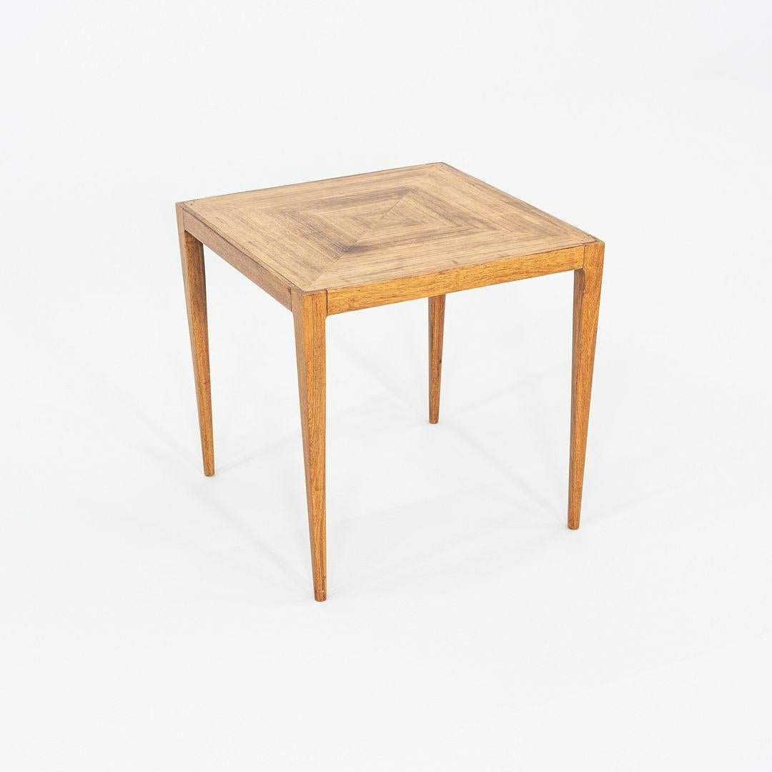 This is a Square Inlaid Walnut Side or End Table, designed by Paul McCobb for Calvin Furniture in the 1960s. It has a geometric pattern of inlaid wood on its top, and has four sophisticated, on-tone tapered legs. 

This table measures 20.25 inches