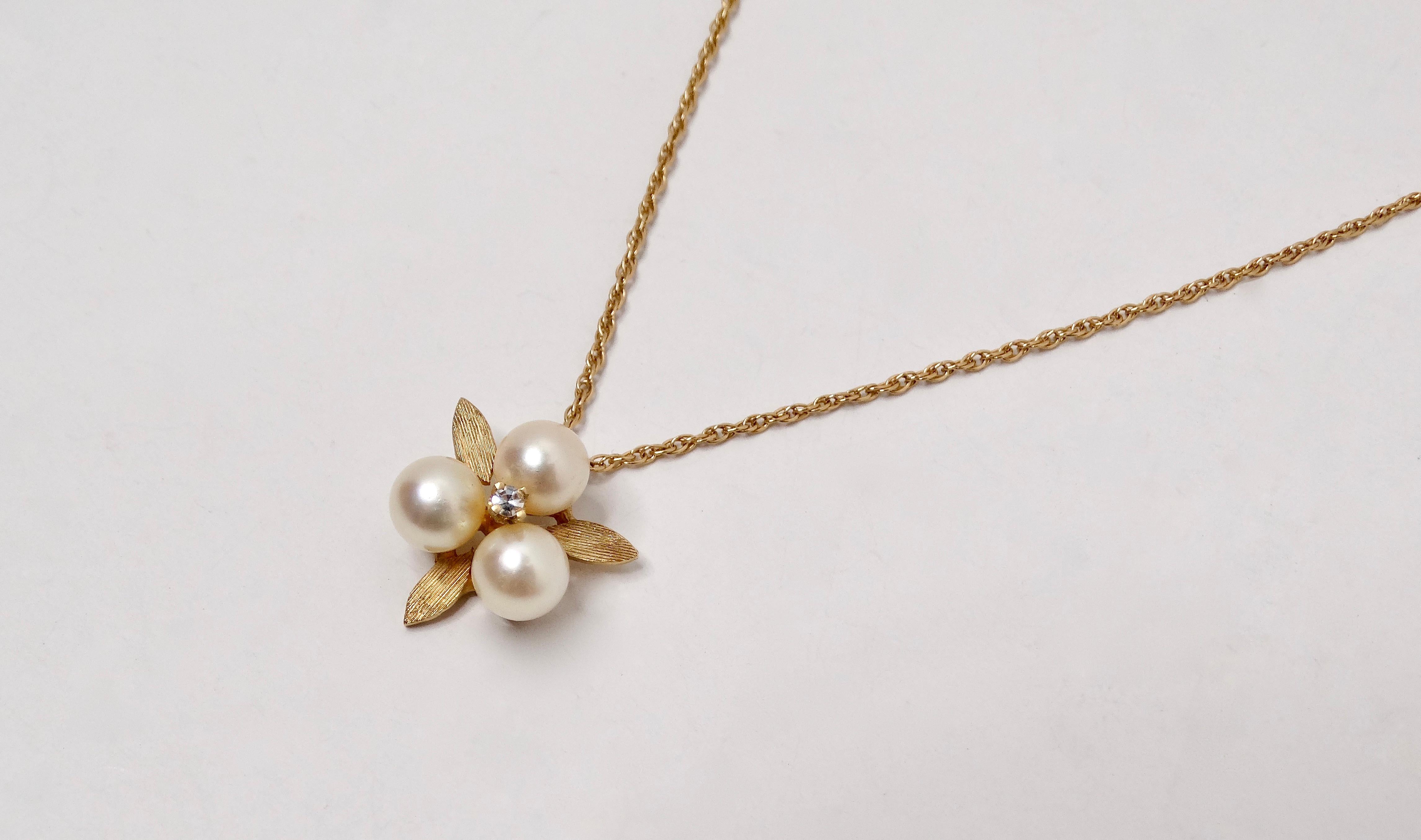 This exquisite 1960s Pearl Cluster 14k Gold Chain Pendant Necklace is a stunning testament to delicate craftsmanship and timeless elegance. The 14k gold chain, known for its rich hue and durability, gracefully supports a captivating pendant centered