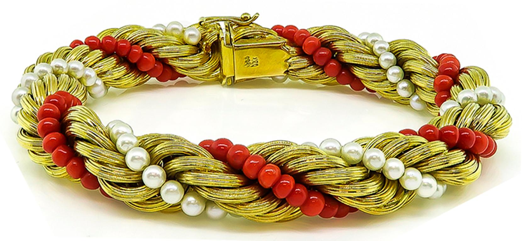 Cet élégant bracelet en or jaune 18k des années 1960 présente un motif de corde torsadée accentué par de jolies perles et coraux. Le bracelet mesure 11 mm de large et 8 pouces de long. 
Elle est estampillée 750 18K et pèse 46,1 grammes.
Inventaire