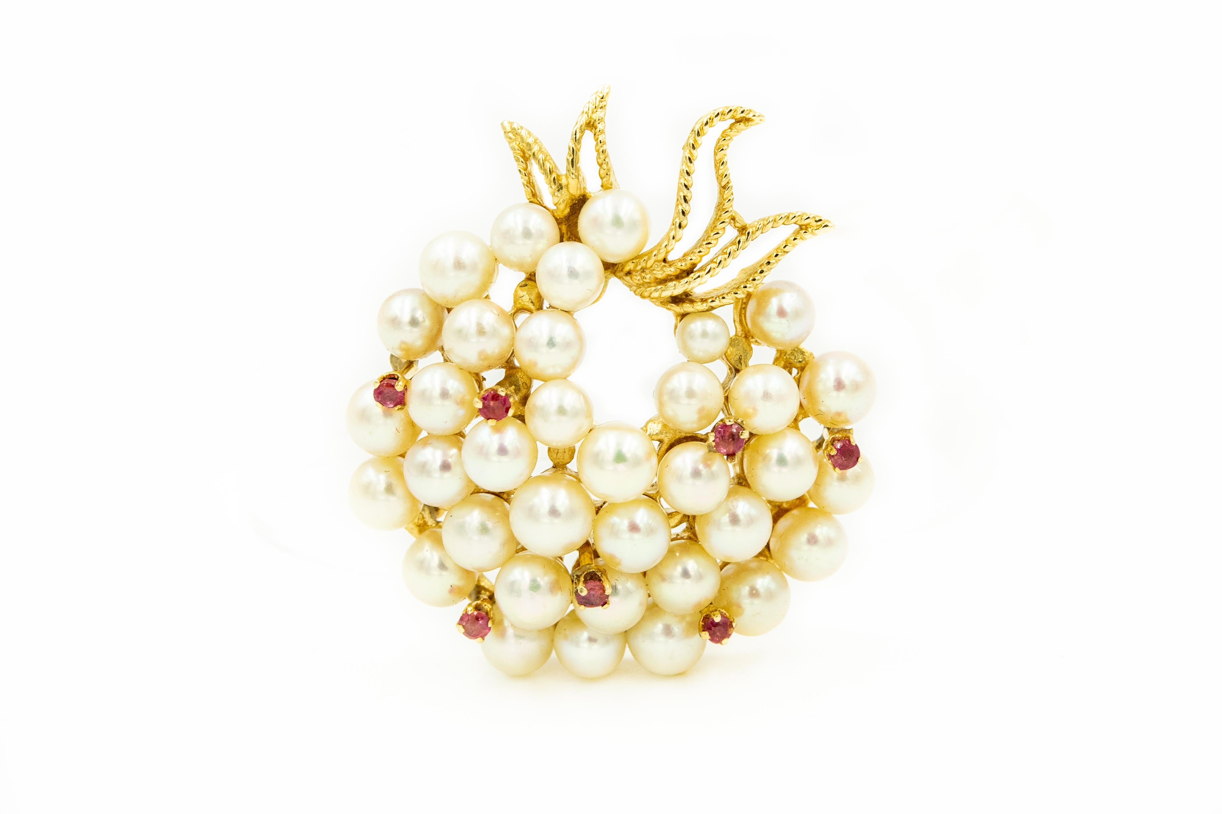Wonderful 1960s three dimensional graduated cultured pearl brooch with ruby accents and a twisted gold bow at the bottom.  This circle design brooch resembles a wreath or a bouquet.

Marked 14k on the back 

It was purchased with a pearl ring that I