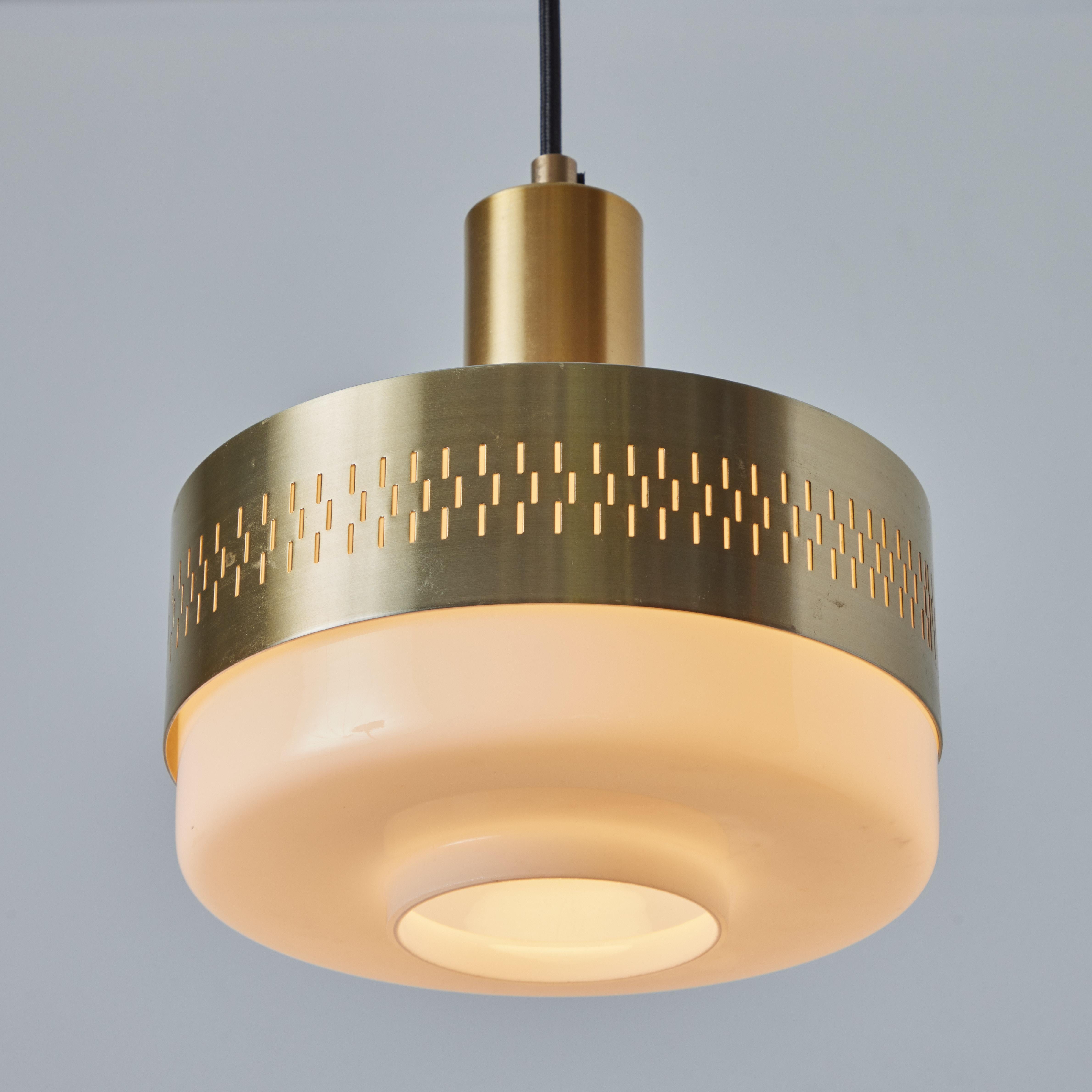 1960s Perforated brass & glass pendant attributed to Hans-Agne Jakobsson. Graced with simple Scandinavian curves and pleasing brass patina. A highly sculptural pendant lamp of attractive scale and incomparable refinement. Unmarked.

Price is per