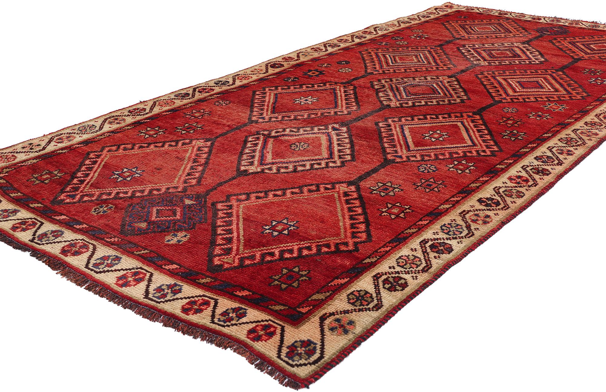 79079 Tappeto Vintage Persian Shiraz, 04'05 x 09'05. Questo tappeto persiano vintage Shiraz in lana annodato a mano è una magistrale dimostrazione di arte tribale, con un design vibrante e ricco di tradizione. La composizione centrale è