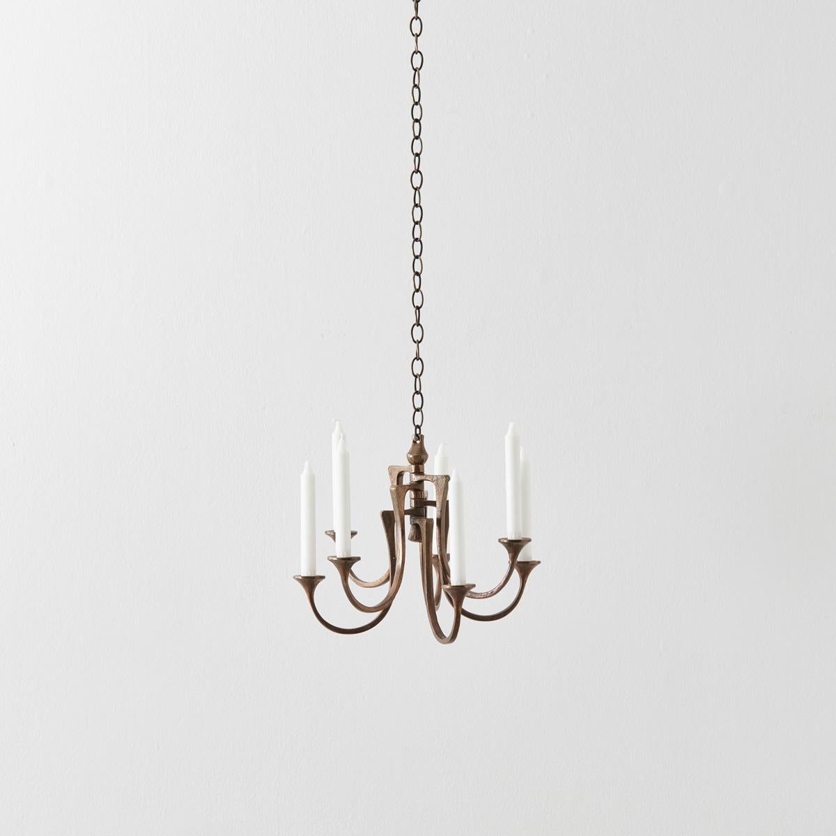 Made from solid bronze in a rich matt tone, this pendant chandelier has a subtle grandeur.
Its seven arms curl upwards, flaring at the ends into candlestick holders. Creating a series of striking chandeliers and candelabras as well as furniture,