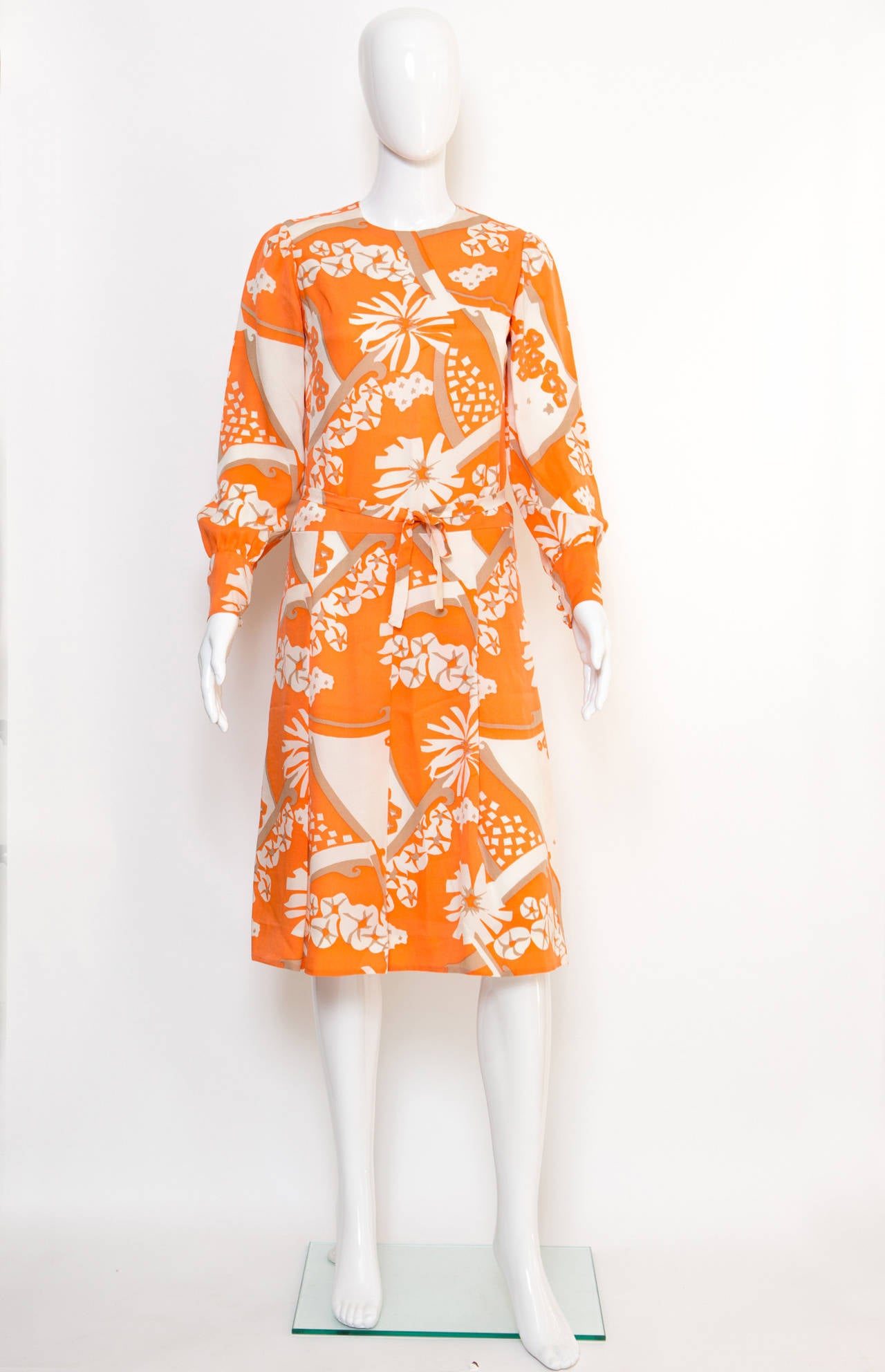 Philippe Venet orange & beige silk printed, featuring a round neck, long sleeves, button cuffs, a rear zip fastening and a separated belt (127 cm x 2 cm). 
In excellent vintage condition. Made in France.
Estimated size  36fr/ US4/ UK8
We guarantee