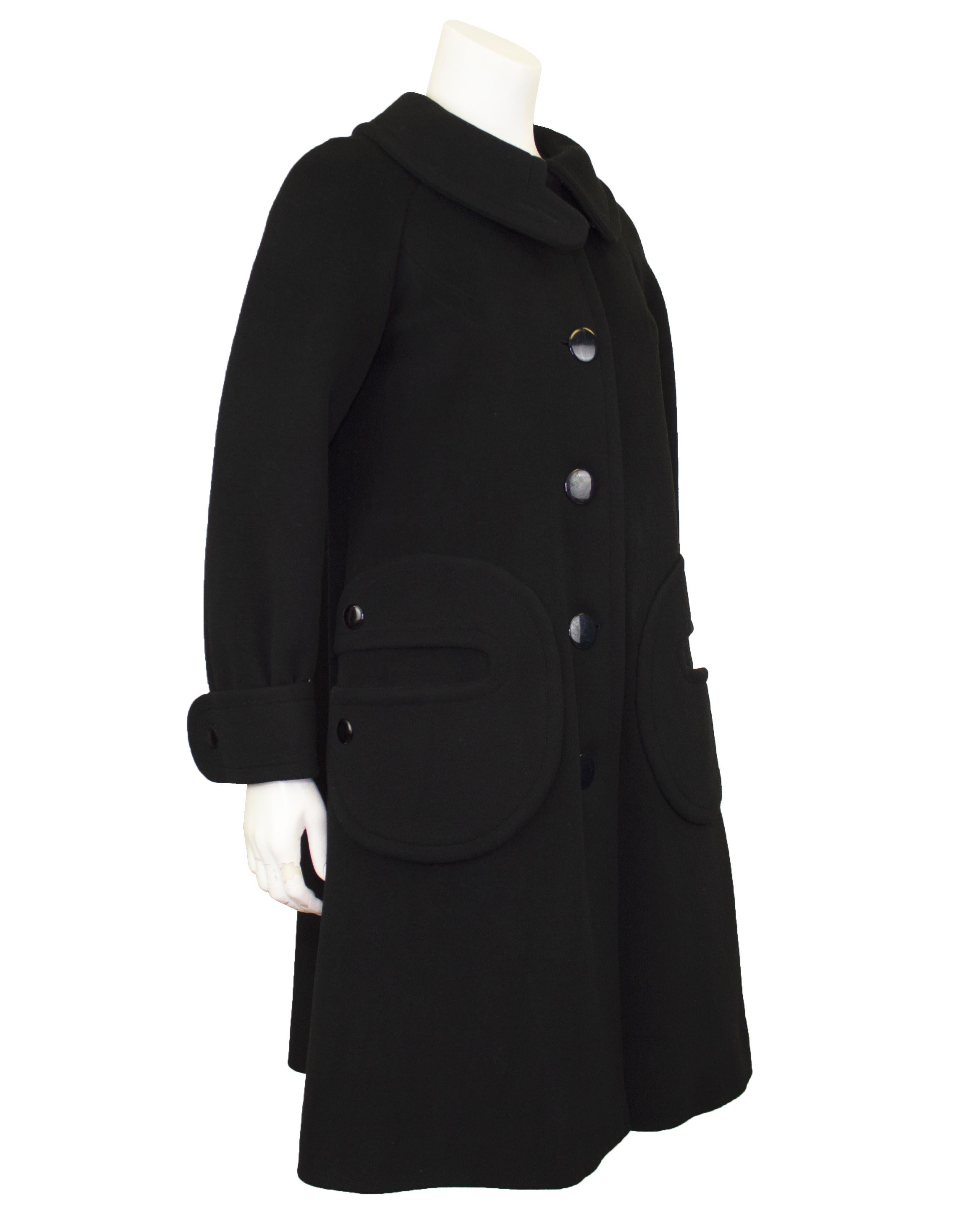 Ce manteau de laine noire Pierre Cardin des années 1960 est une pièce emblématique de la mode de l'époque. Elle illustre l'approche avant-gardiste de Cardin en matière de design et sa vision novatrice de la mode futuriste. Fabriqué en laine noire de