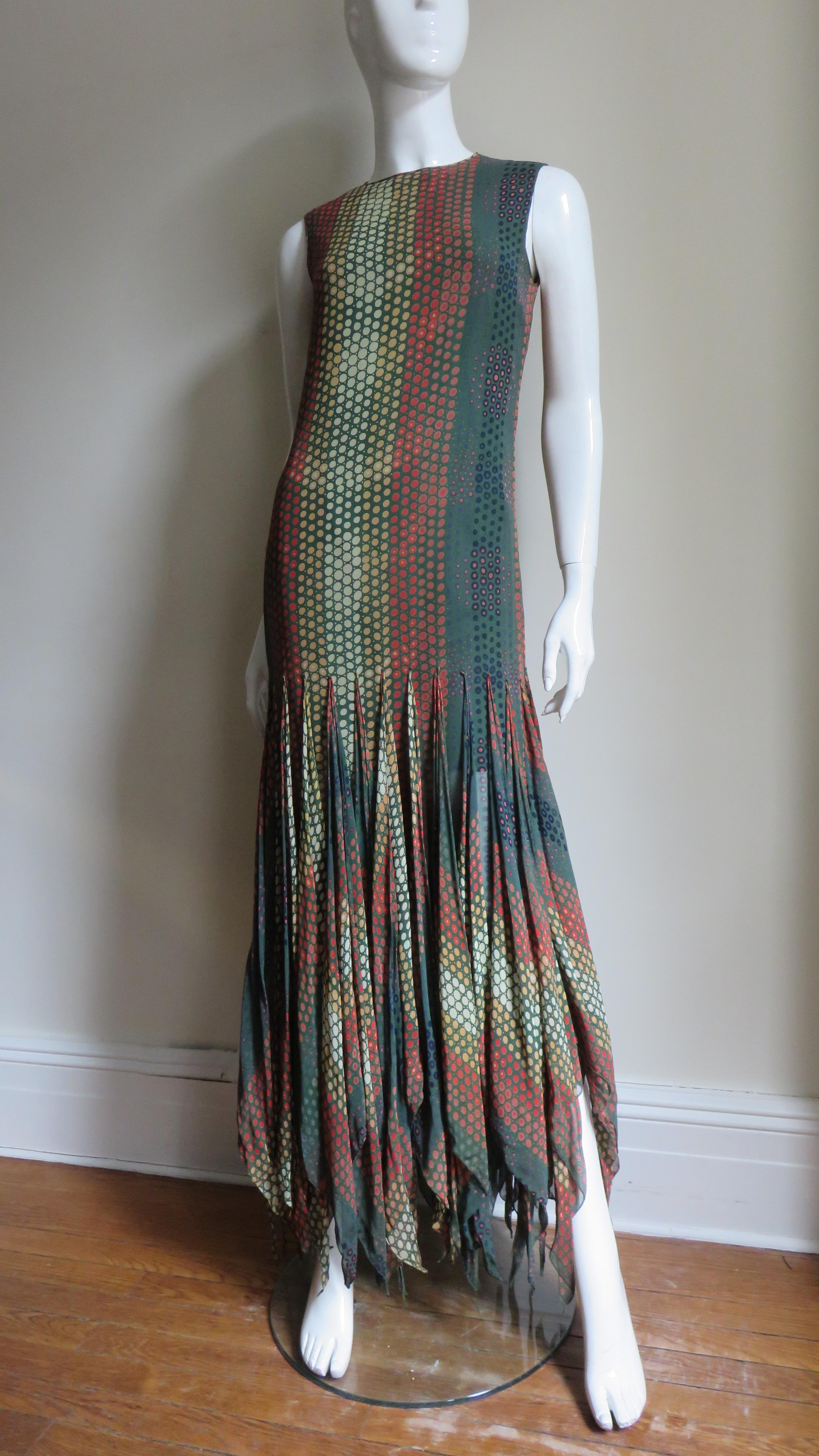 An incredible forest green silk maxi dress with red, orange, rust, blue and celery green dots by Pierre Cardin. The dress is sleeveless with a crew neck and attached by a point at mid thigh level a row of individually finished squares of the fabric