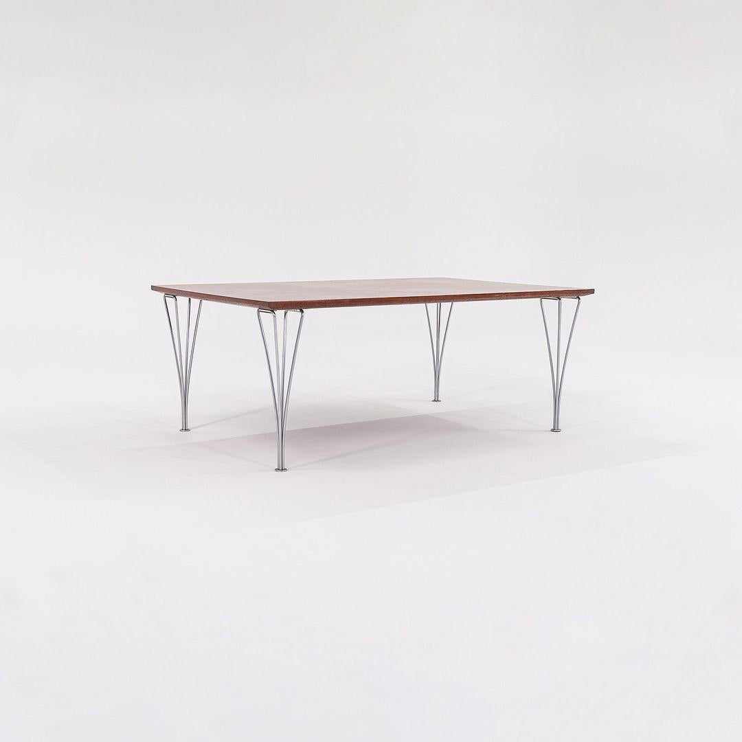 Il s'agit d'une table basse en teck, conçue à l'origine par Piet Hein, Bruno Mathsson et Arne Jacobsen. Cet exemple particulier a été produit dans les années 1960 par Fritz Hansen. Le design se compose d'un plateau de table en teck et de pieds en