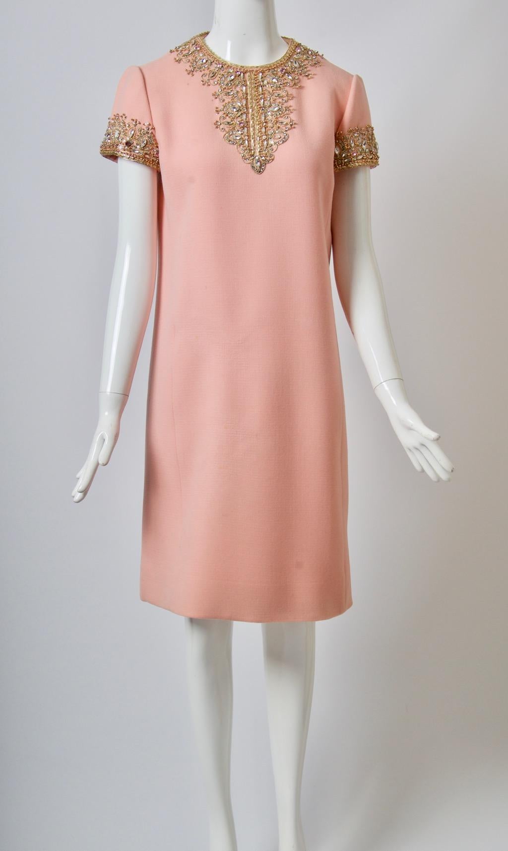 Pink wool crepe shift dress, the round neckline and short sleeves embellished with intricate beading consisting mostly of varied crystals and gold thread. The slightly A-line silhouette has front seaming from the underarm to the hem. Lined in pale