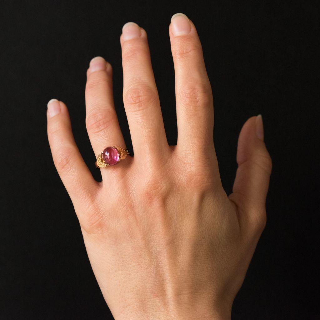 Ring in 18 carat yellow gold.
A stunning and original antique ring claw set with a pink Tourmaline cabochon. The beginning of the ring band is formed of 2 chiselled gold leaves on each side. 
Total weight of tourmaline: about 2.40 carats.
Width: 9,5