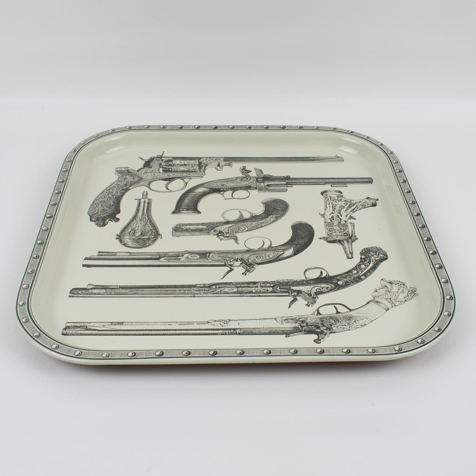 Studio Fornasetti pistol tray from the 1960s, design attributed to Piero Fornasetti, Italy. Very decorative square enameled metal tray featuring a cool and quirky print of antique pistols, guns, and gunpowder pouches. The underside has a printed