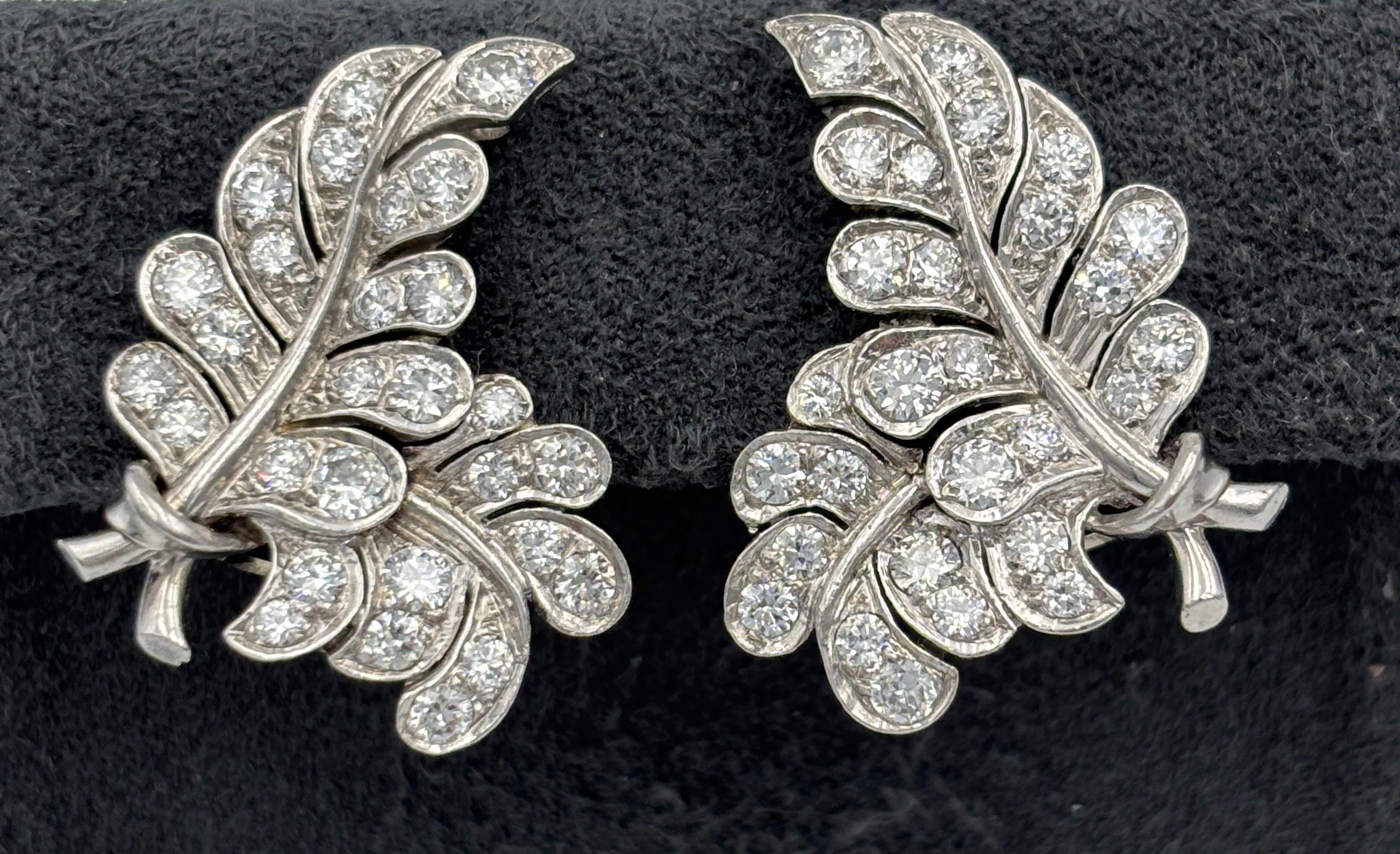 These delightful 1960s platinum and diamond earrings are completely hand-made. This is clearly visible when you study the 2 earrings together. There are slight differences in the shapes of the leaves. They truly are beautiful made.

The earrings are
