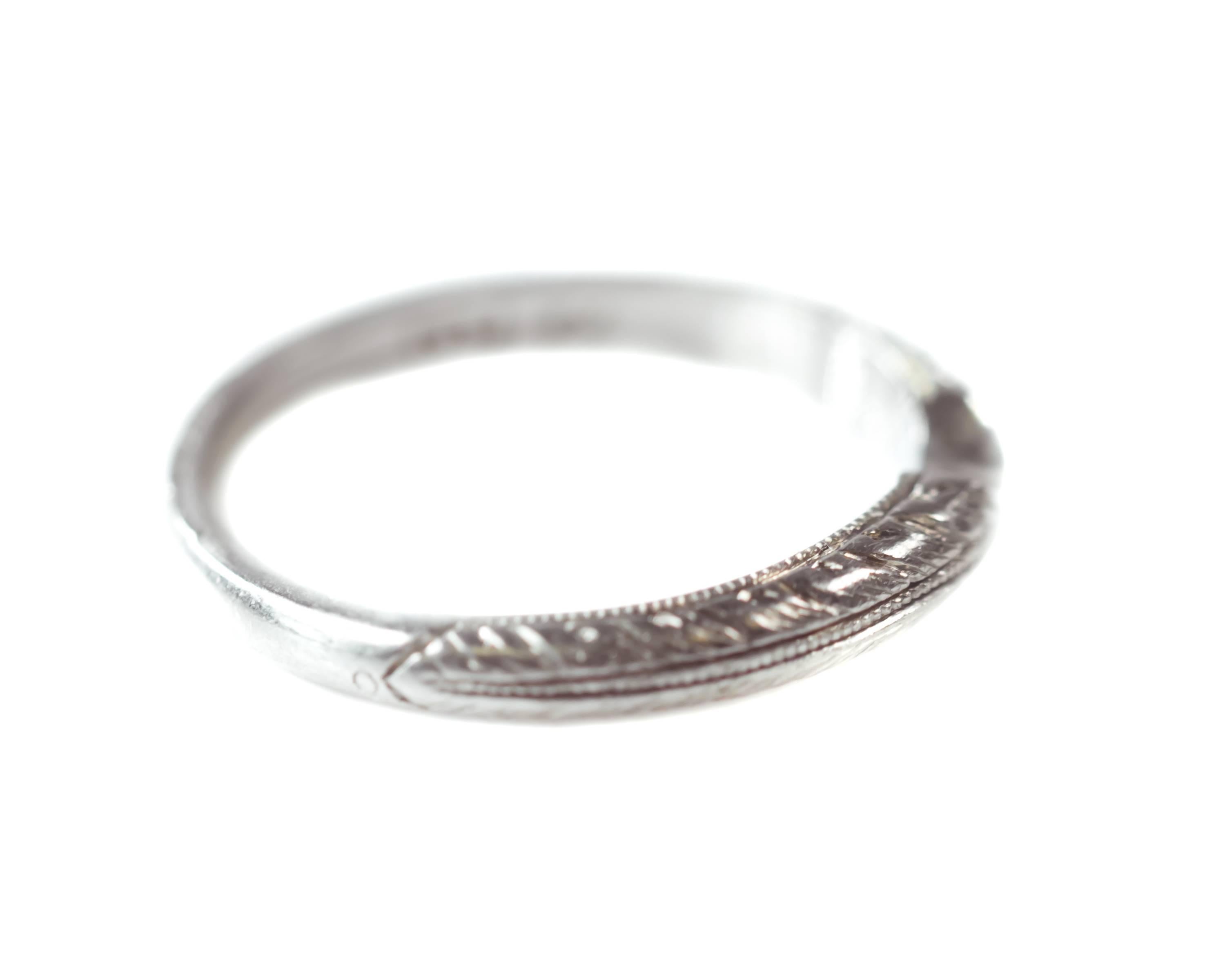 1960s Retro Curved Wedding Band - Platinum

Features a delicate etched pattern along the front half of the shank. The upper and lower edges of the band are etched with a delicate feather pattern. The feather pattern frames the fine milgrain work
