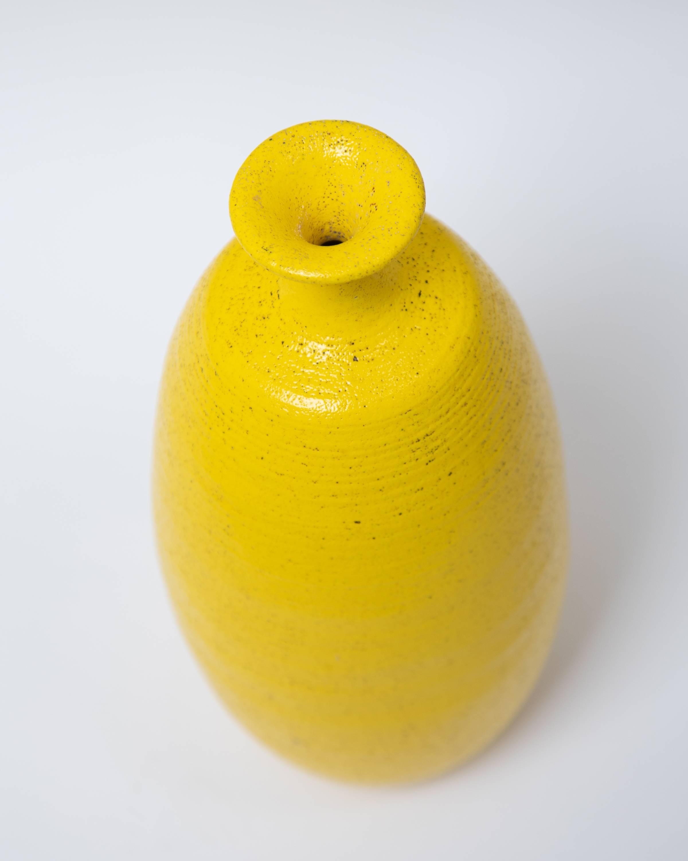 Handgefertigte Flaschenvase aus Keramik mit gelber Glasur im Pop-Art-Stil, ca. 1960er Jahre.
Auf der Unterseite gestempelt USA.