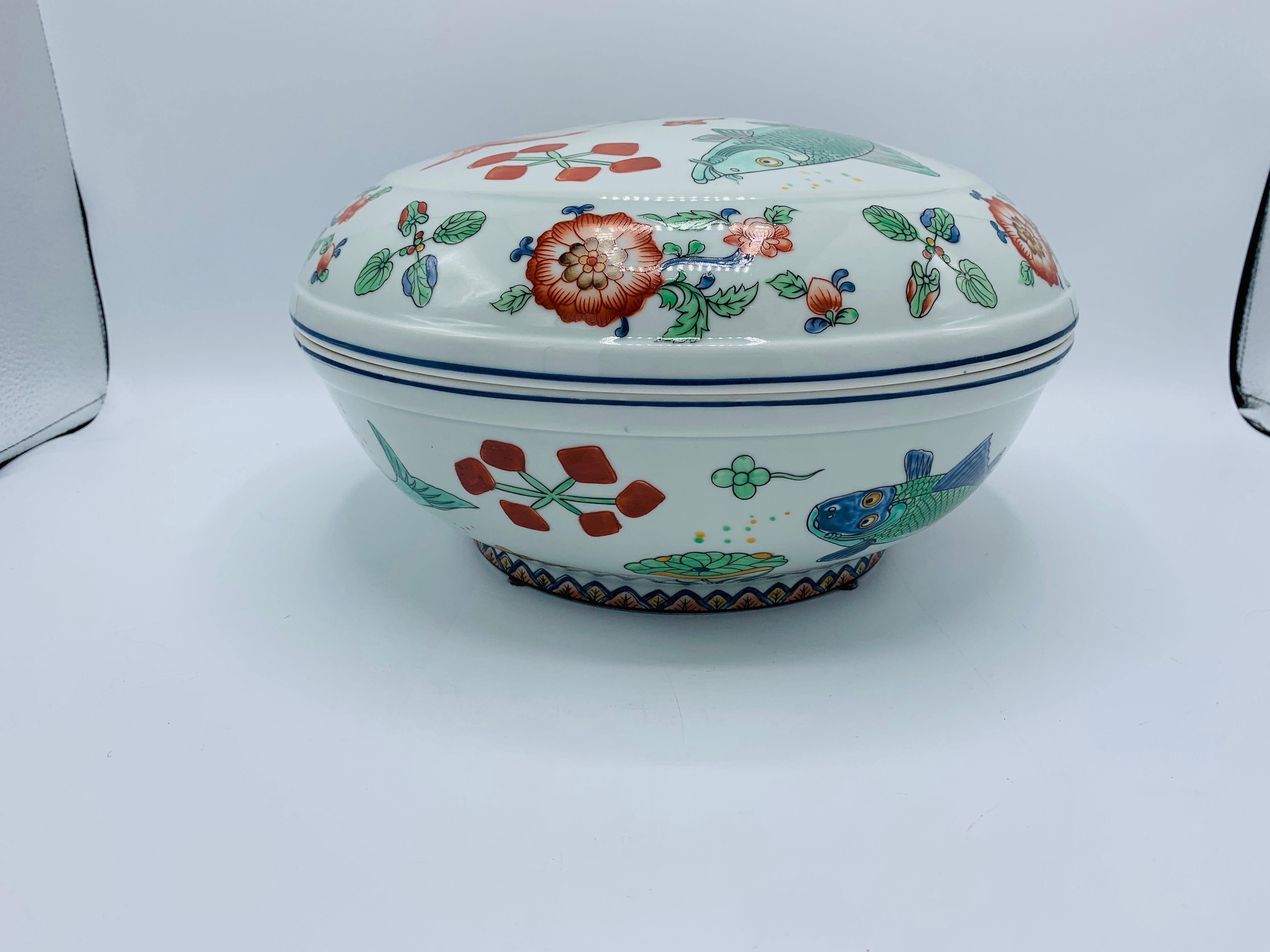Listed is a gorgeous, 1960s chinoiserie porcelain lidded tureen bowl. The piece has a beautiful, hand painted fish motif all-over. Perfect for formal serving! Heavy, weighing 6.6lbs.
