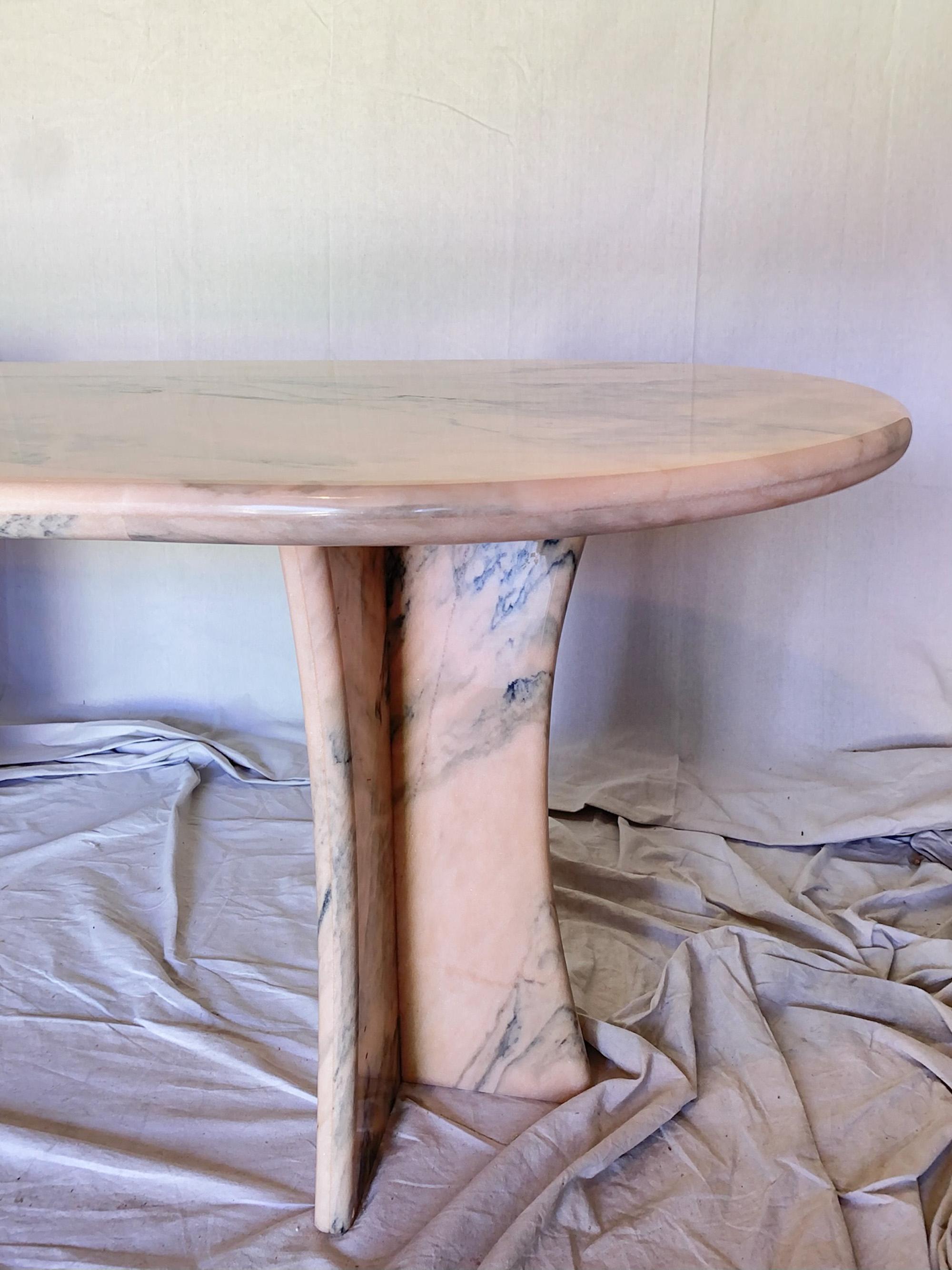 Gorgeous 1960s Portuguese Rosa marble dining table imported from Spain and made in Portugal. This statement piece has hues of pink and peach with beautiful blue-grey veining. The oval table top has 2