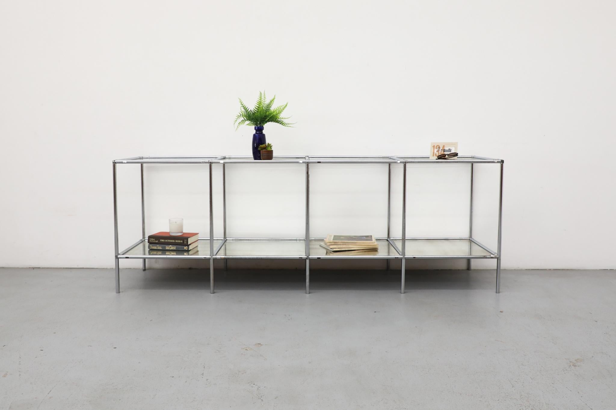 A rare and unique modular shelving unit, this Poul Cadovius 'Abstracta' system features a chrome frame and four glass-fronted cubicle sections. The unit is equipped with four upper inset glass shelves and four lower antique mirrored shelves,