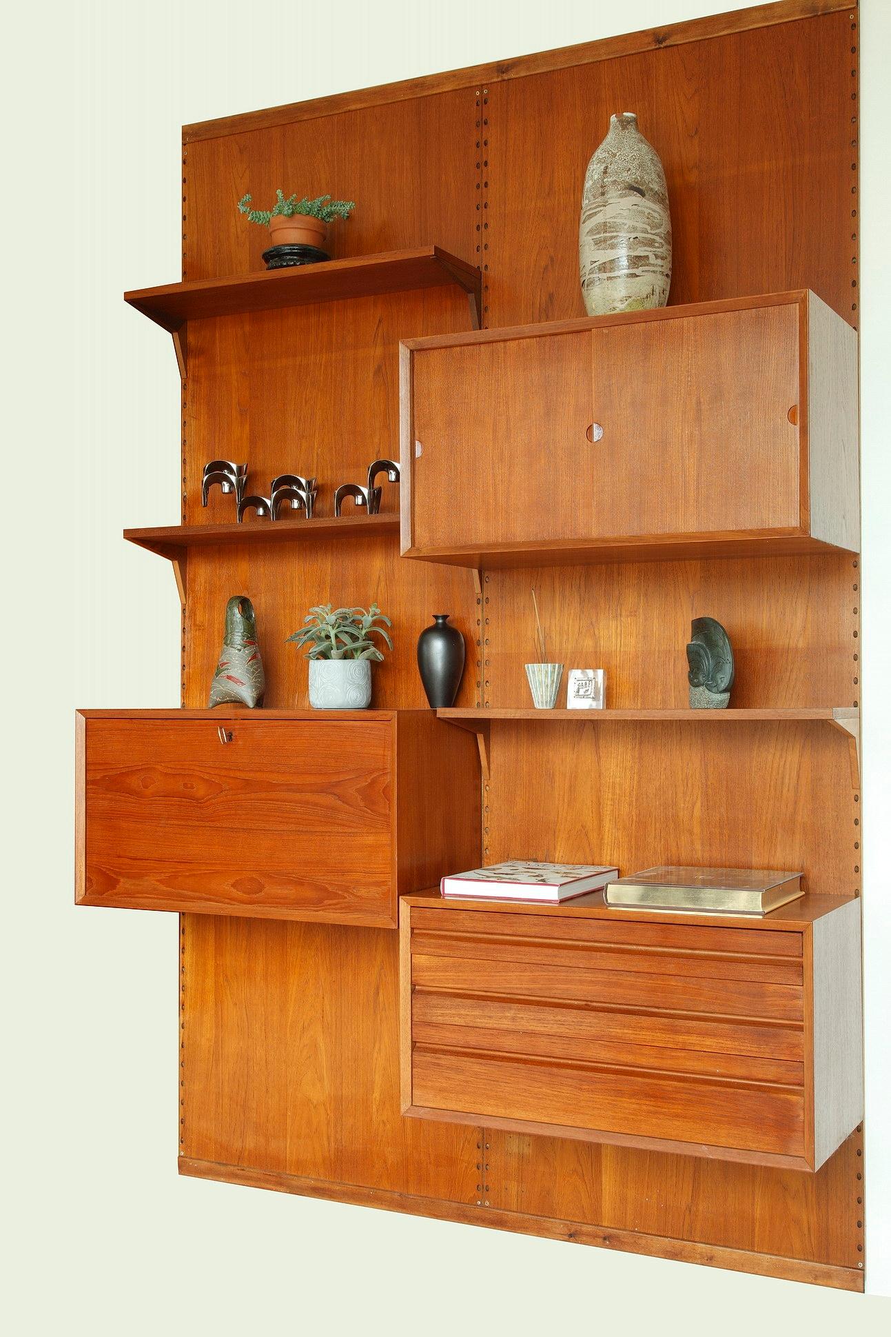 Poul Cadovius wall unit crafted of teak in the 1960s. This modular Scandinavian shelving system consists of two vertical panels with shelves and cabinet units:
- 3 shelves (P 22cm)
- 1 cabinet unit with sliding doors (P 42cm, H 38cm)
- 1 cabinet