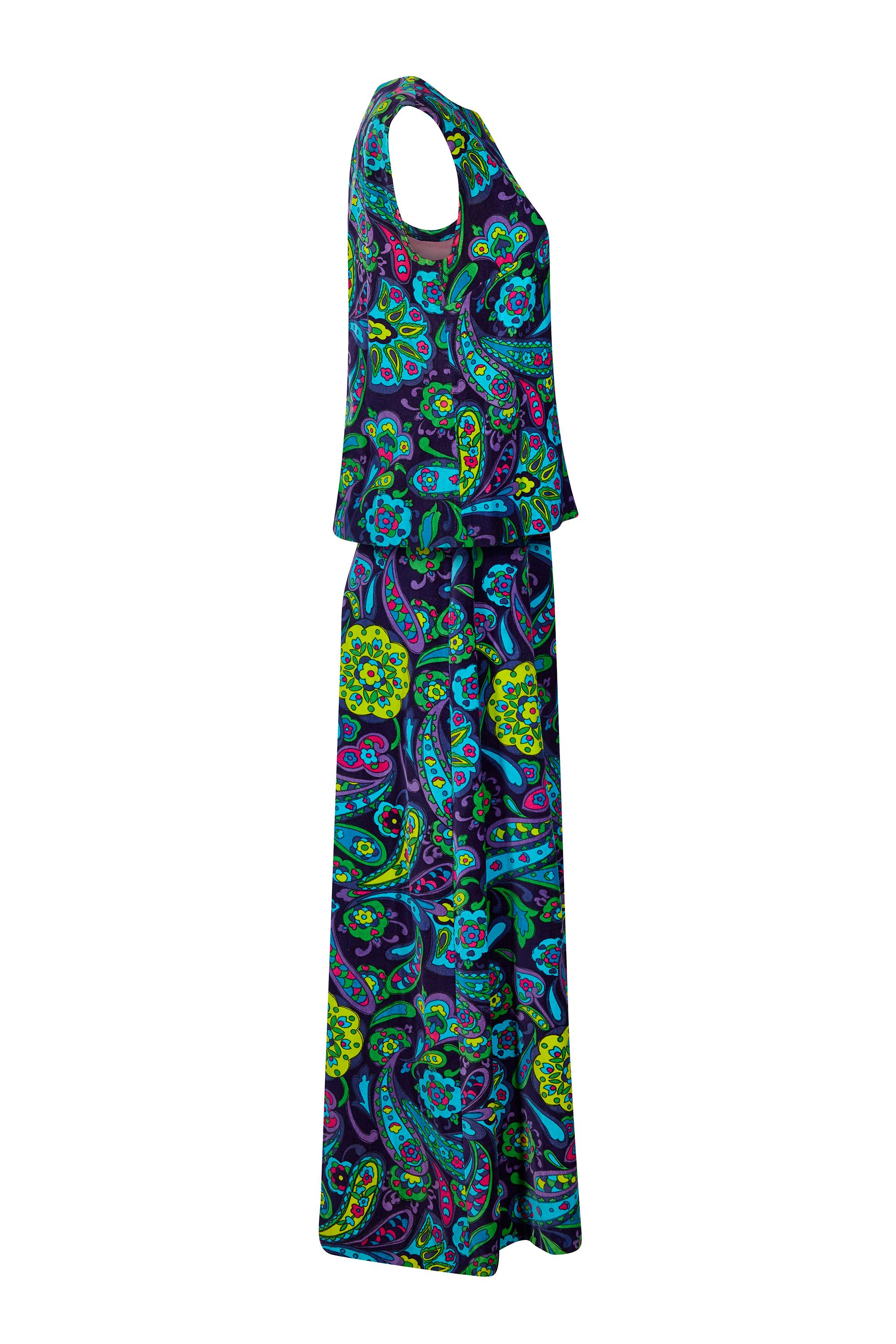 Cet ensemble vibrant en velours de coton des années 1960 se compose d'une jupe longue à la cheville et d'un haut sans manches à l'imprimé psychédélique flamboyant en paisley fuchsia, turquoise, vert lime et lilas sur un fond indigo profond.