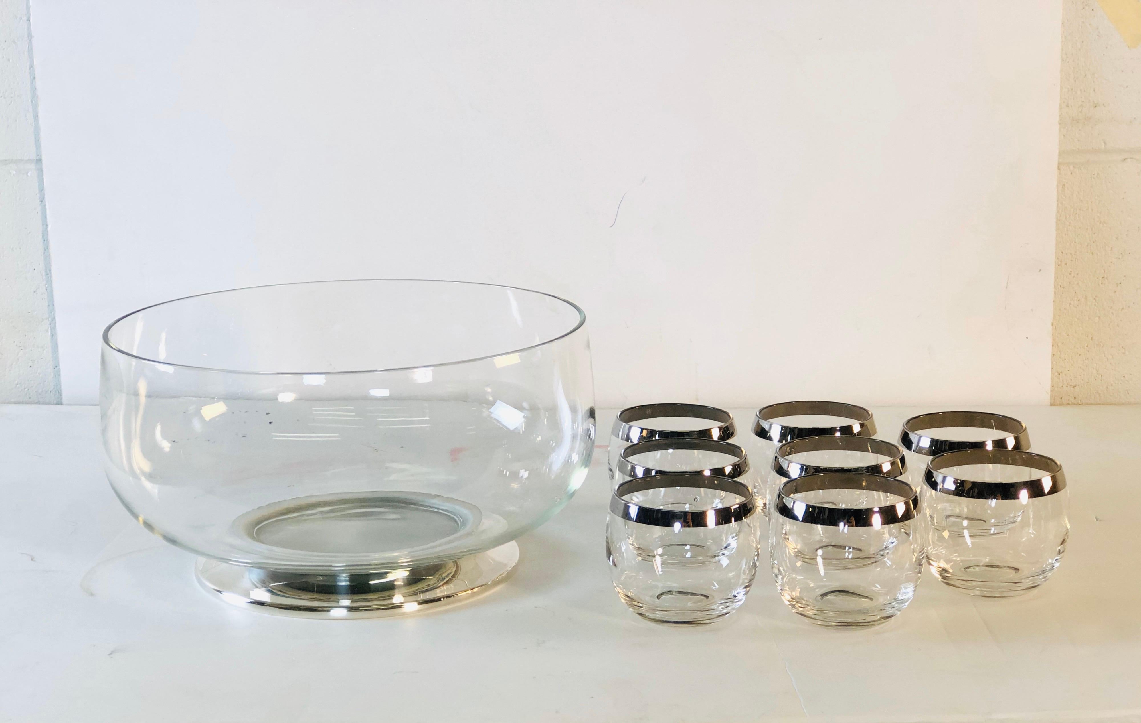 1960s glass punch bowl set with 8 silver rim roly poly style tumblers. The punch bowl has a silver plated base and the glasses all have a silver rim. No marks. Glasses measure 3” diameter x 2.75” height. Excellent condition.