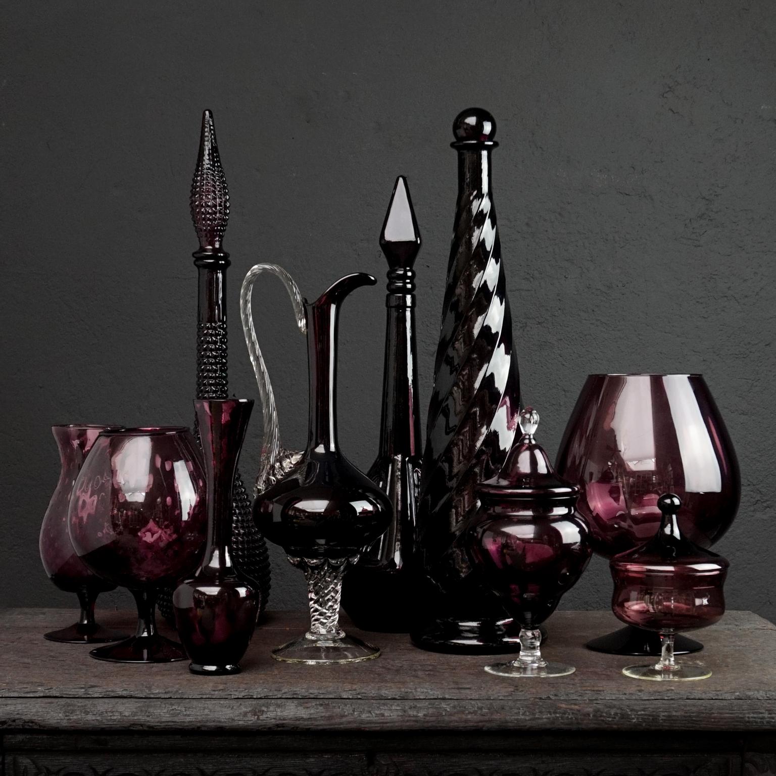 Very decorative aubergine, amethist, plum coloured purple set of ten different size and colour Italian art glass bottles, vases and apothecary or candy jars.

Mention Italian glass and probably everyone’s mind immediately leaps to Venice and