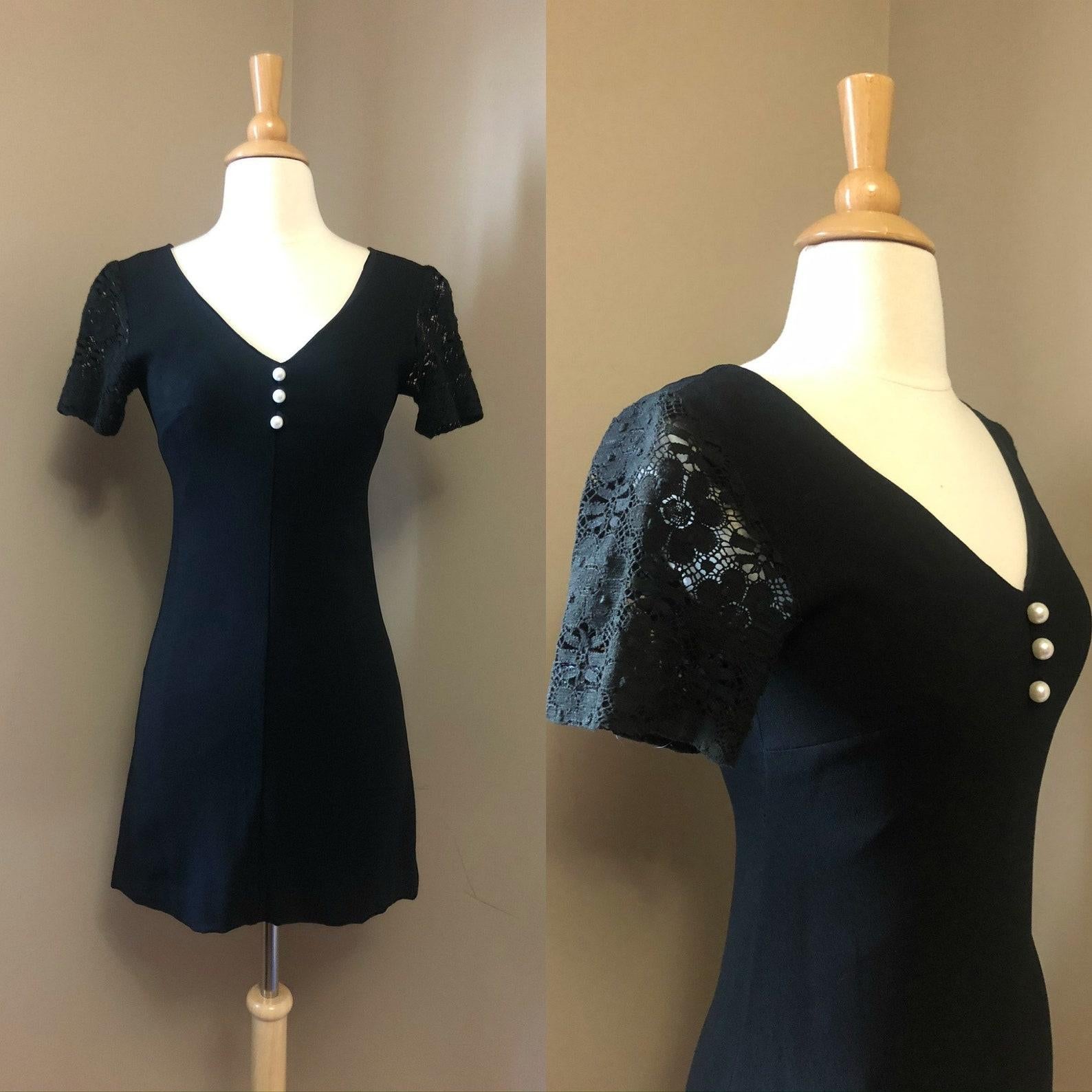 Rare vintage Radley of London black mini dress. A-line silhouette, v neck collar, short crochet lace sleeves. 
3 gum ball sized faux pearl decorative buttons along the bodice. 
Back metal zipper closure. 
Dress is lined, sleeves are unlined.

An