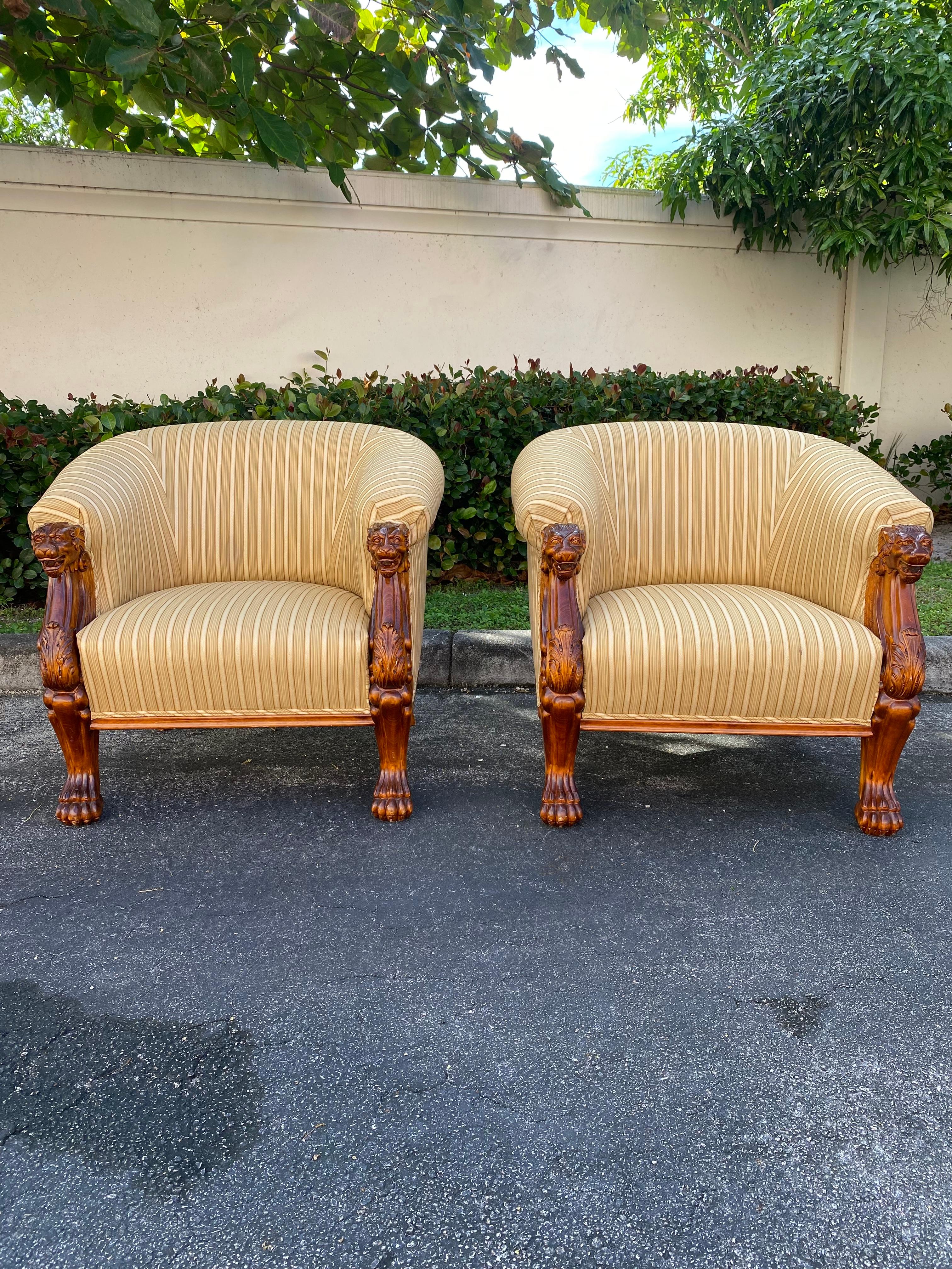 A dramatic pair of large scaled barrel tub chairs with carved lion heads and realistic carved legs ending in paw feet. These extremely rare and stylish upholstered tub chairs are packed with personality! Heavily lions motif along with gorgeous