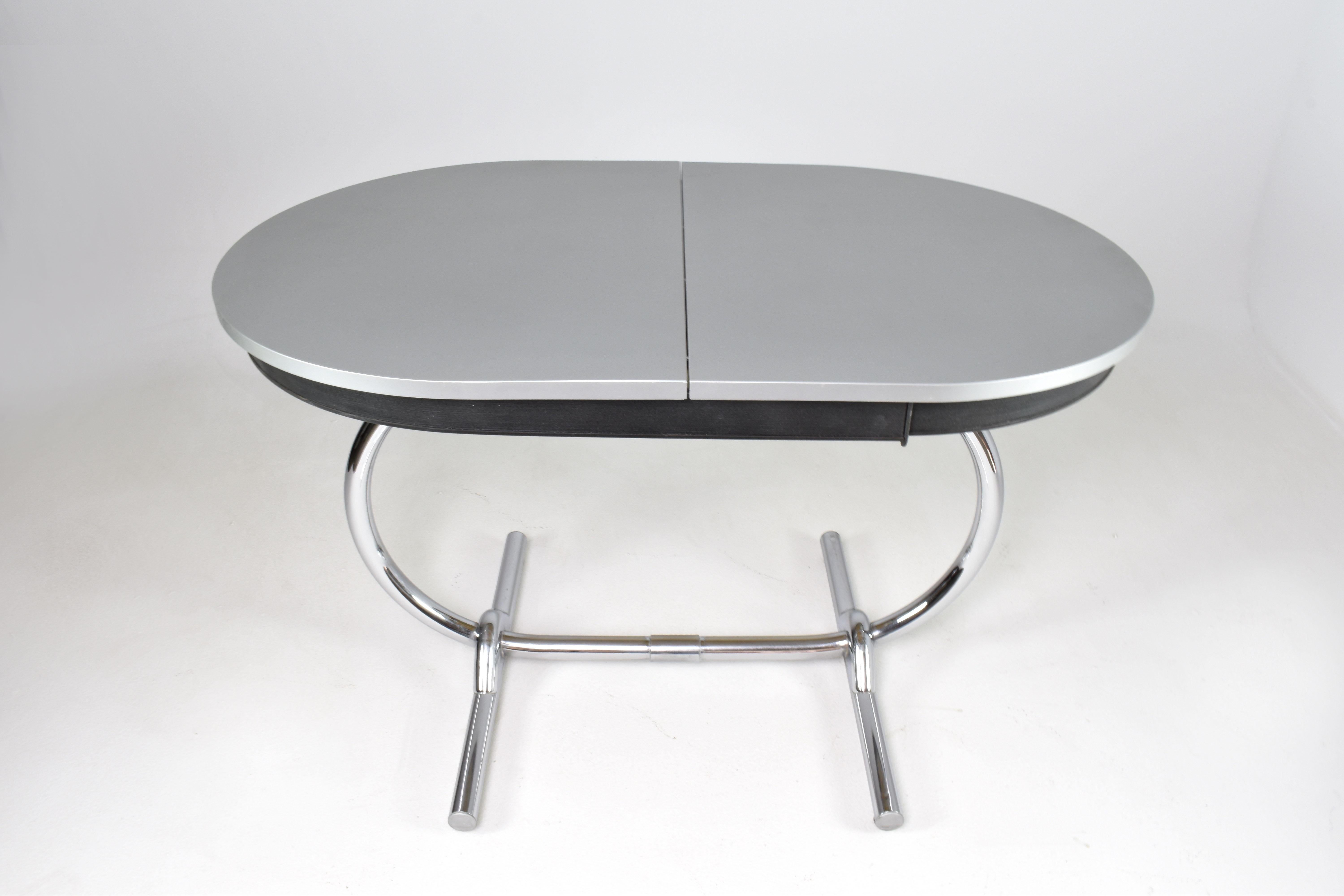 Very beautiful oval-shaped Formica table with extension leaves, featuring chrome metal legs, in good condition. The product is a rare find from the 1960s. 

Maximum Length: 161 cm (63.4 inches)
Minimum Length: 120 cm (47.2
