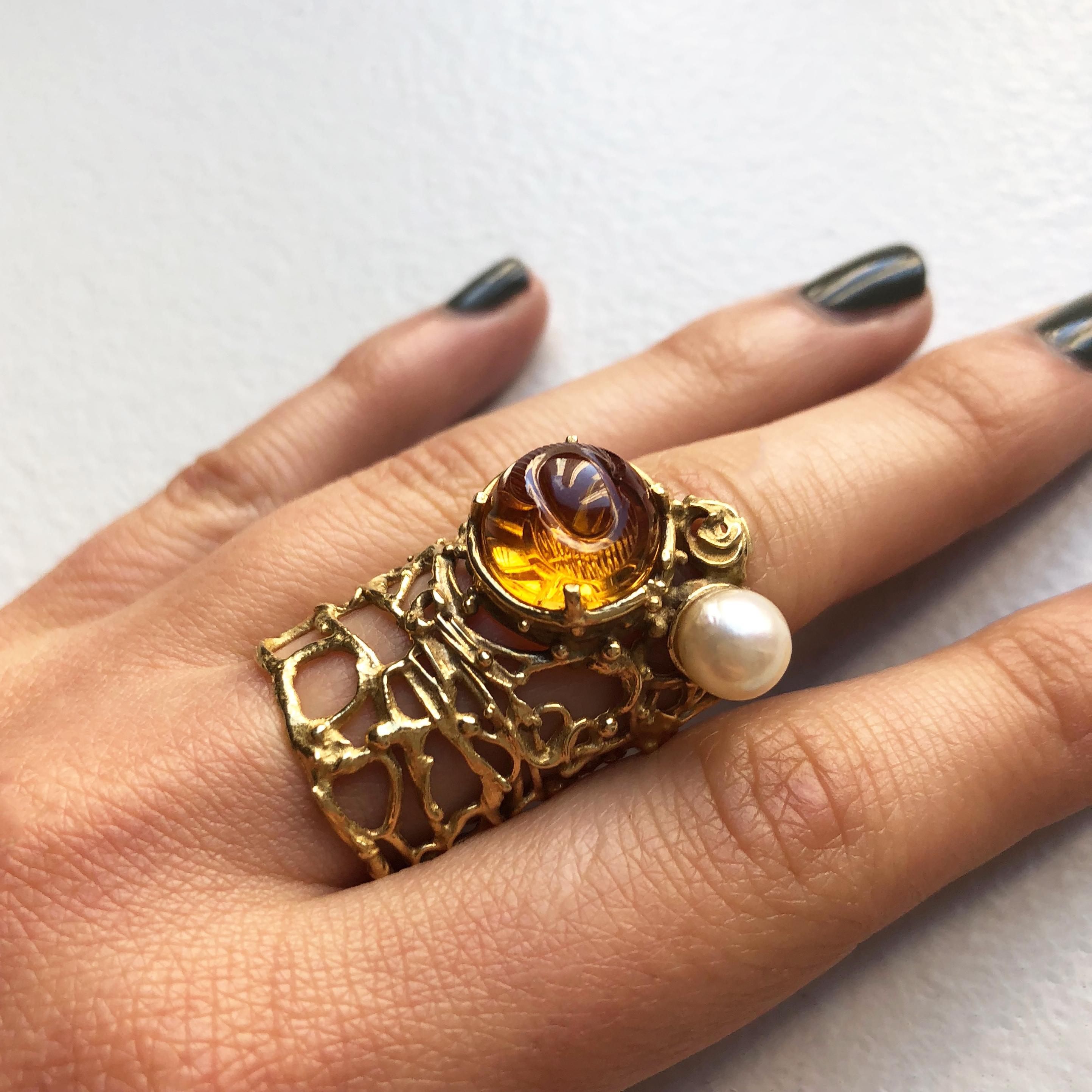A collectible carved citrine, cultured pearl and 18 karat gold ring, by Gerda Flöckinger, c. 1965. The ring measures a size 6. 

Gerda Flockinger (b. 1927)  is one of Britain's most revered living artists. A daughter of immigrant Austrian parents,