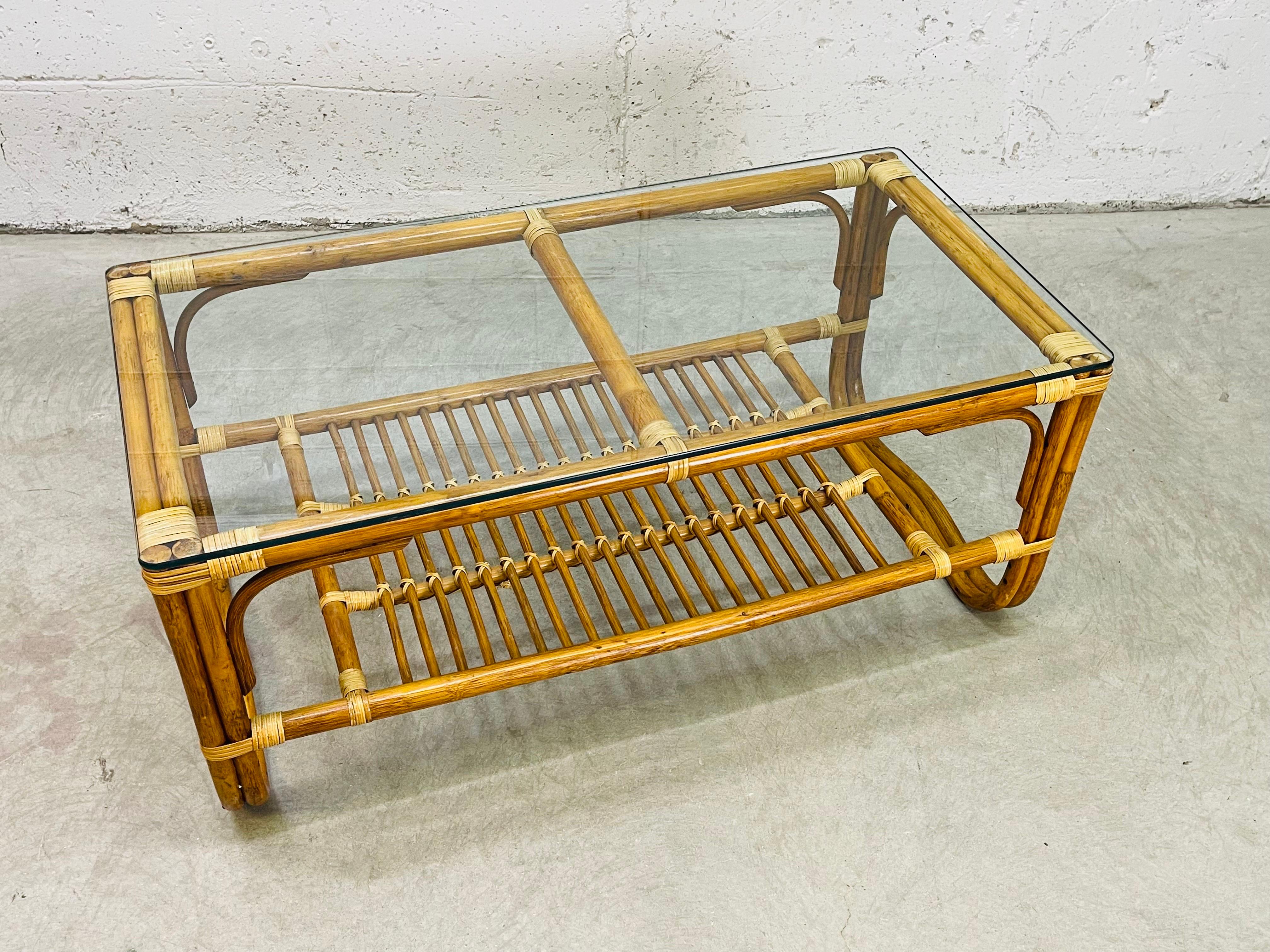 Vintage 1960s rattan two strand and glass top rectangular coffee table. The table has an additional shelf for storage. The shelf is 7.5”H. Excellent condition with no breaks to the rattan. Glass is also in excellent condition with very minor