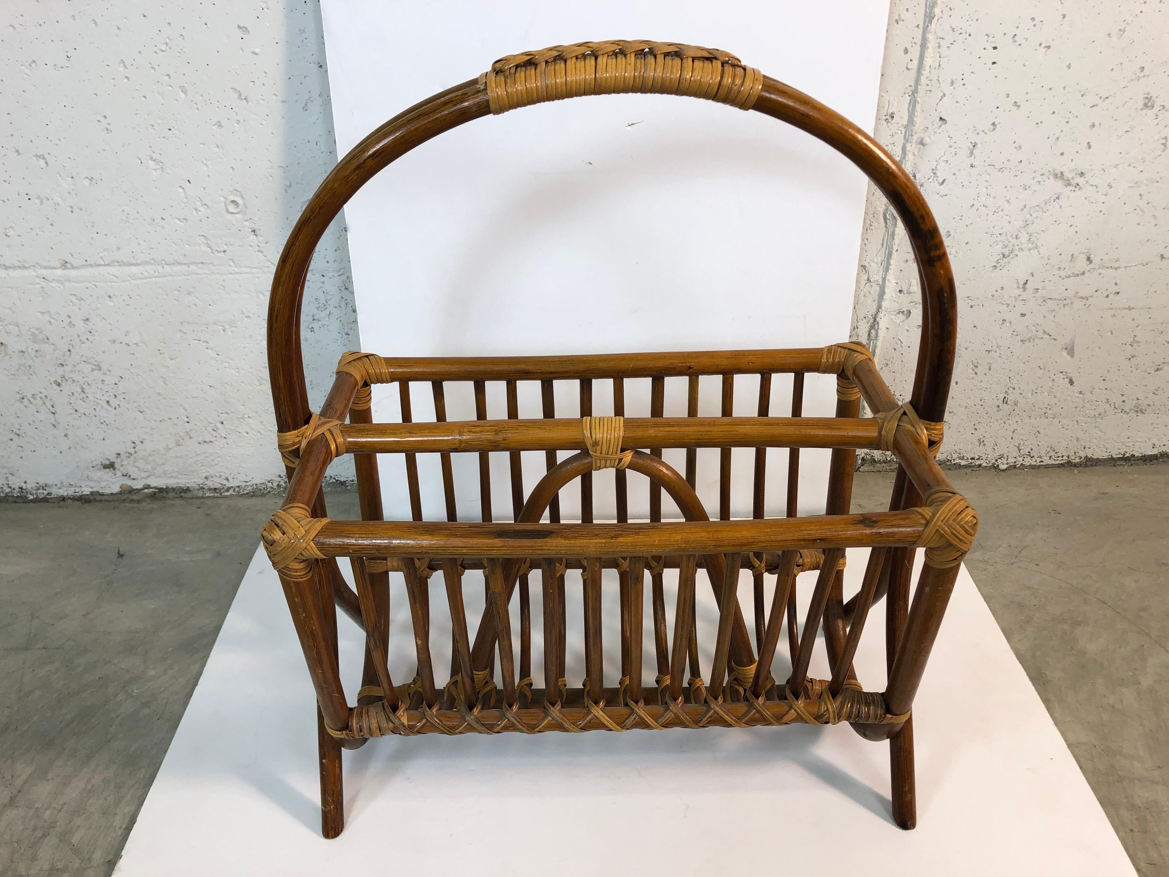 1960s Mid-Century Modern rattan handled magazine rack with weaved accents on the corners and on top of the handle. Very good used condition, no breaks.