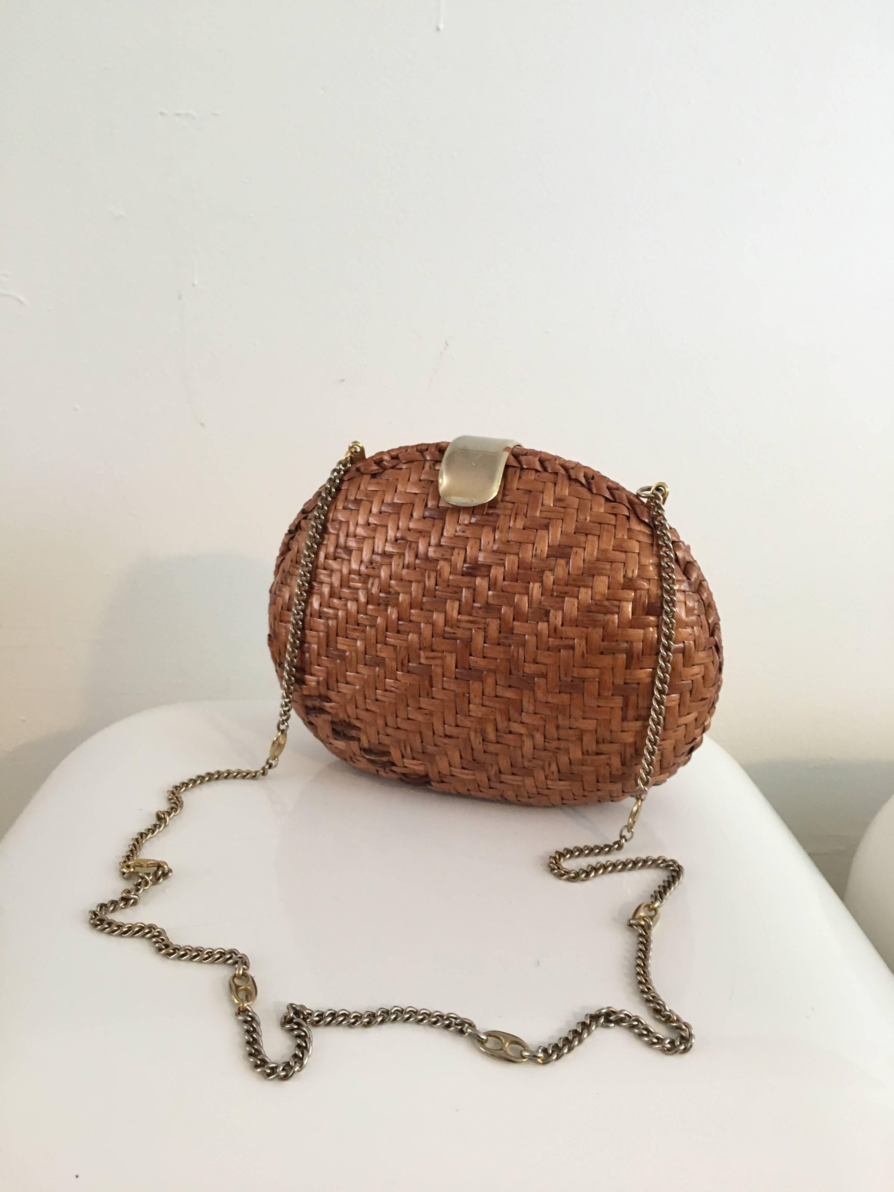 1960s brown rattan shoulder handbag / clutch with brass snap closure is made in Italy.  The interior is made of nice soft cream leather with one zipper compartment.  This is one very timeless shoulder bag / clutch that will have all your girlfriends