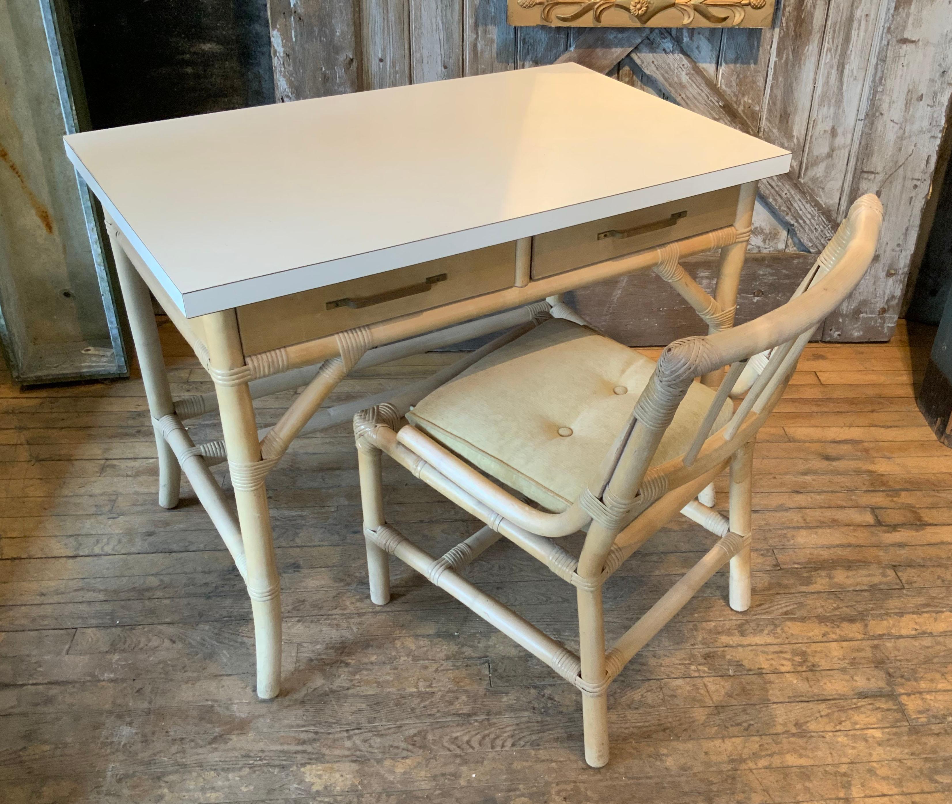 A very nice vintage 1960's rattan frame writing desk designed by Tommi Parzinger for Willow & Reed. charming design and details, with two slim drawers with the original brass hardware, and a laminate writing surface. the desk has its original