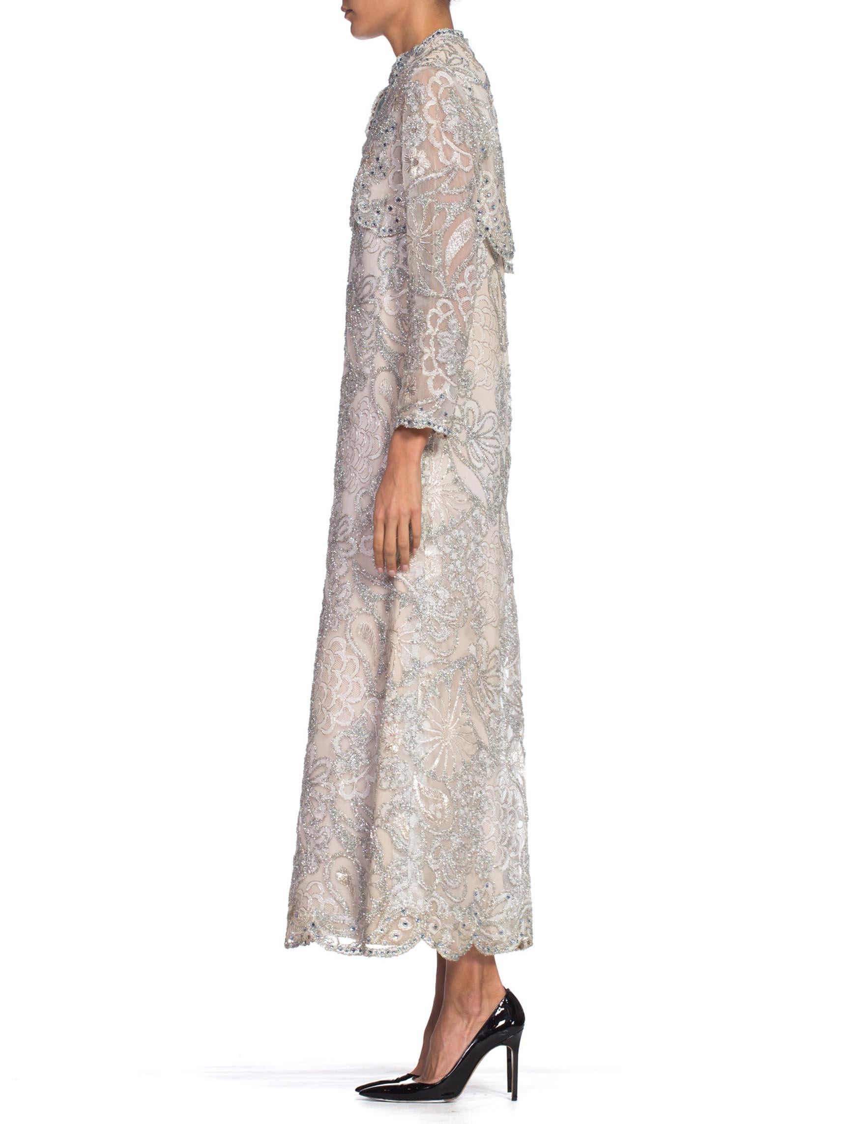 Haute Couture details such as pattern matched lace, hand finishing & horse hair structure. Fully lined in rayon, some slight discoloration from age.  1960S Oyster Grey Rayon Lace Empire Waist Sleeved Gown Embroidered With Real Silver & Lurex Tinsel
