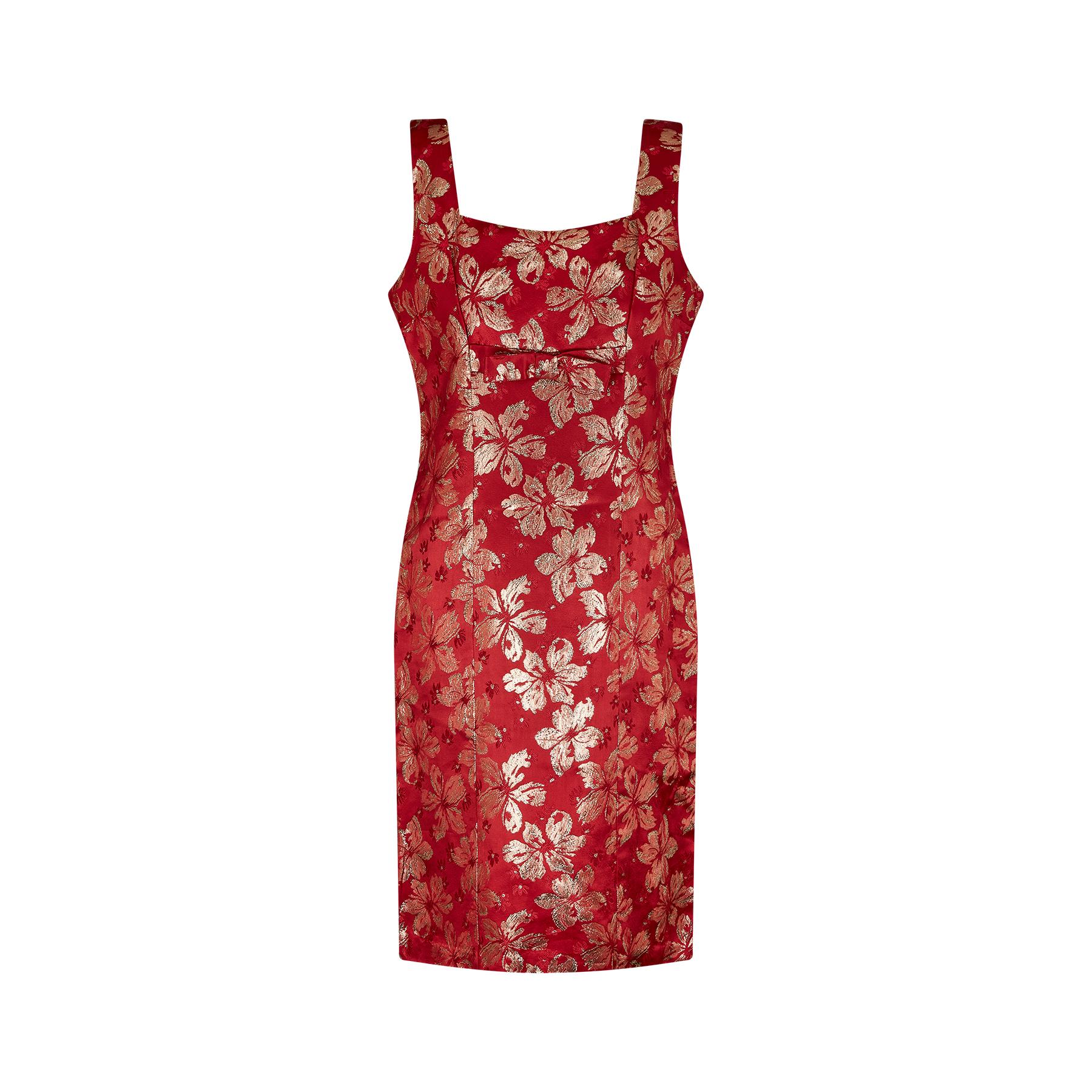 This is a perfect party or cocktail dress in a vivid red and gold medium weight brocade fabric. Dating from the 1960s this dress takes the classic shift style from that era with a high square neckline and thick straps. The bust line is adorned with