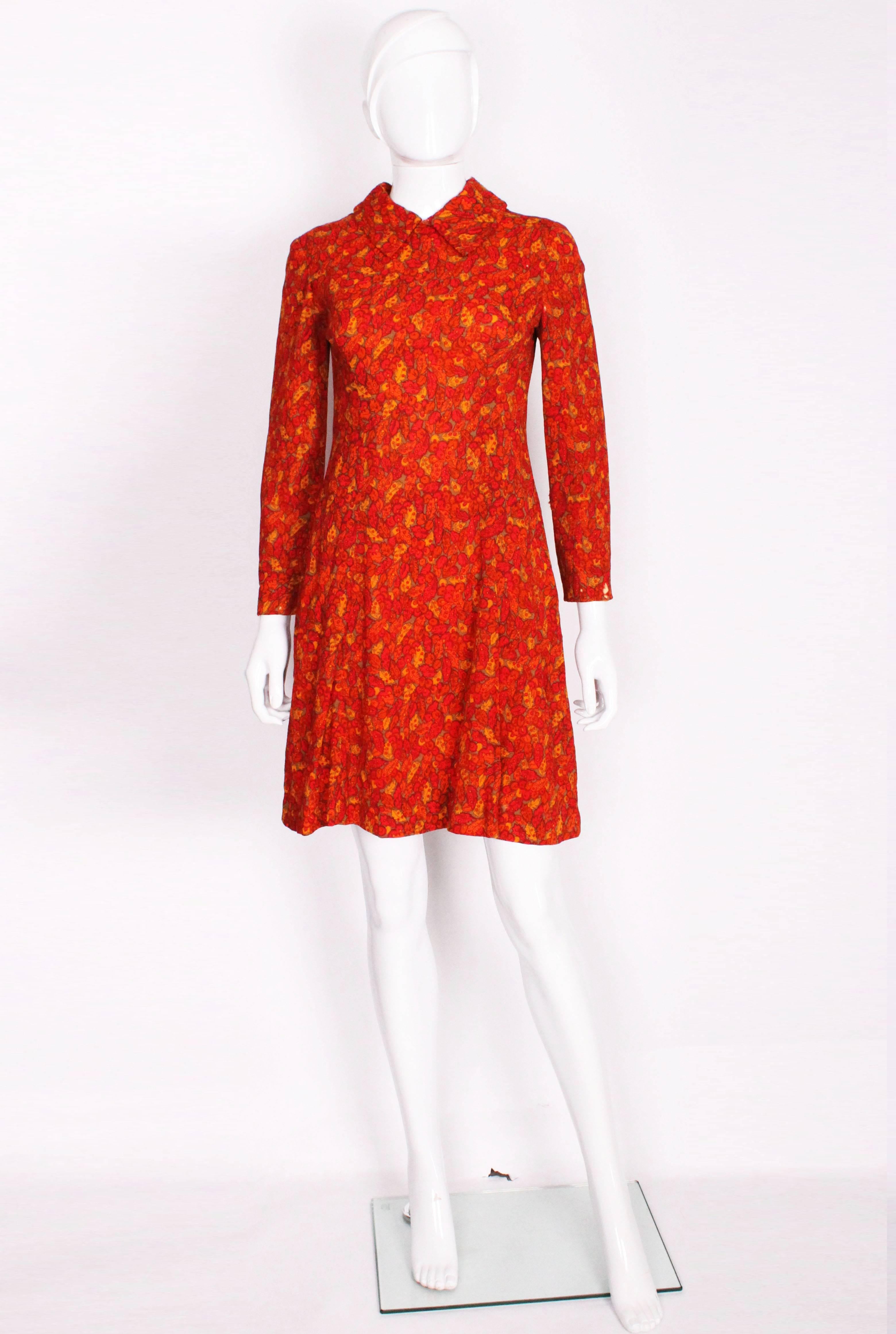 The print of this dress makes it a great piece for an autumnal day. It is a classic 1960's mini dress in lovely bright colours. The fine leaf print is made up of a wonderful mix of firey colours, with tones of red, orange, yellow and brown. It has a