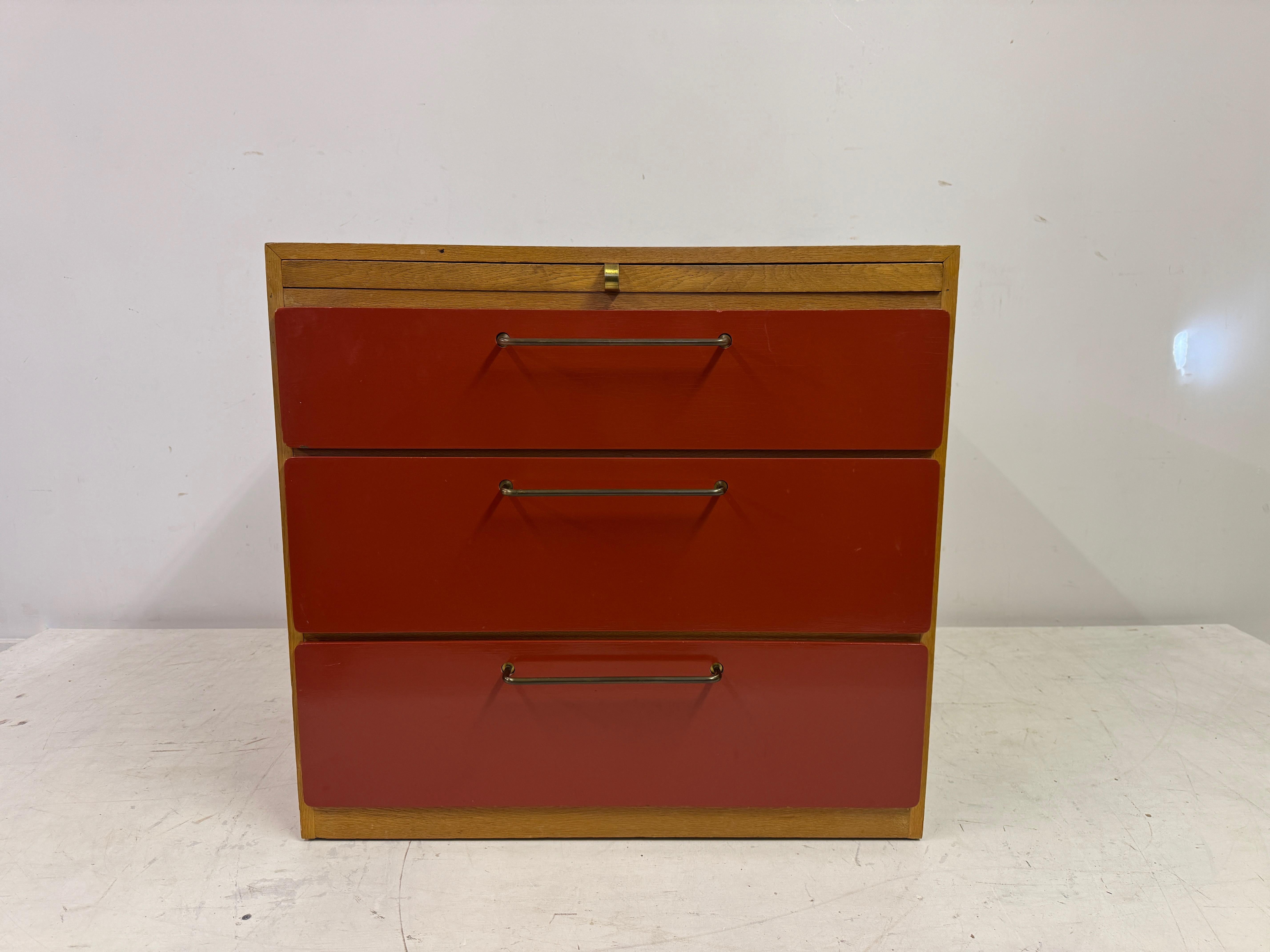 Cassettiera di Heal's

Cassettiera di metà secolo di Heal's, caratterizzata da un sorprendente contrasto tra le venature calde del legno e i frontali dei cassetti laccati di rosso. Il design pulito è accentuato dalle maniglie allungate in ottone,