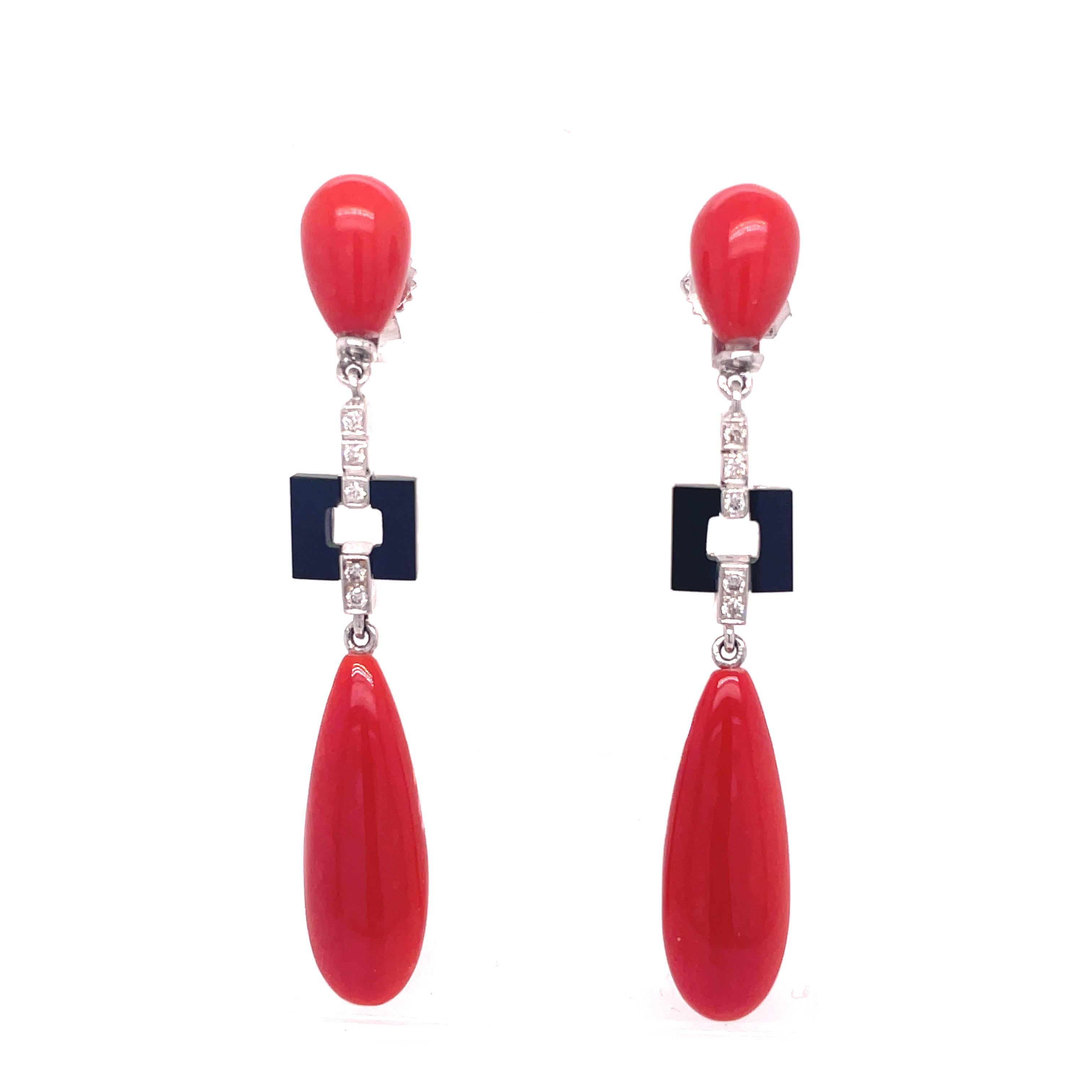 This is an exceptional pair of 1960s earrings, set in 18K White gold, that features bright red coral, bold geometric onyx, and bright white diamonds. This beautiful pair of earrings is fully articulated, so with every movement you make, the earrings