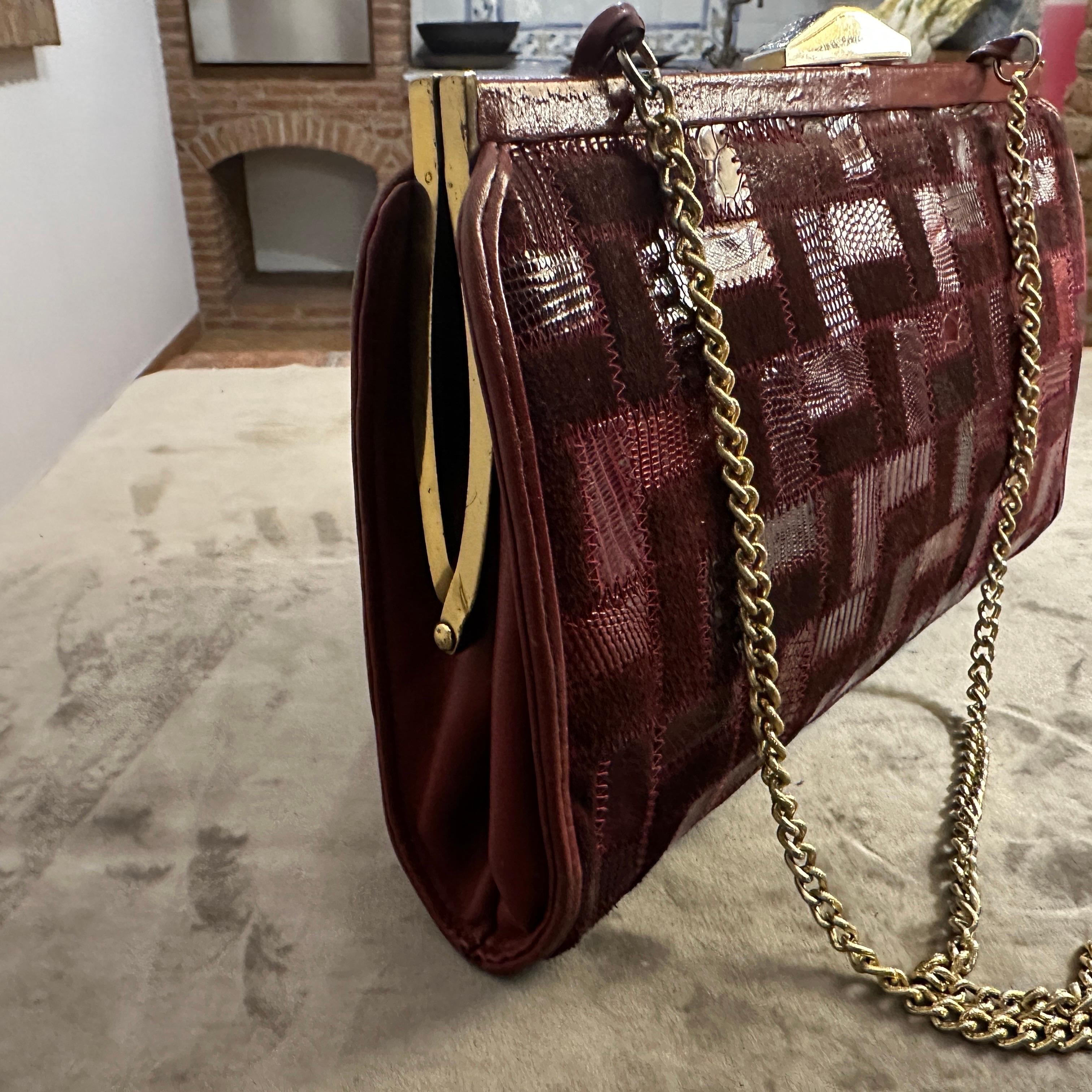 Make a bold statement with this stunning and rare vintage shoulder bag from the 1960s, a true piece of Italian craftsmanship by Niki Milano.
The bag is a masterful example of patchwork design, featuring a beautiful medley of red tones. It's crafted