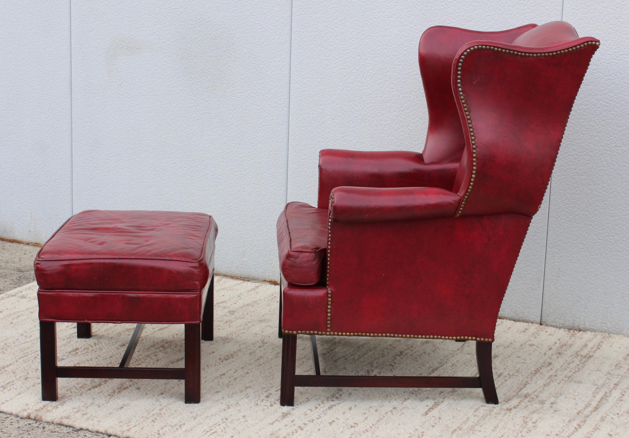 1960's distressed red leather wing-back chair with matching ottoman and brass nail detail by Hickory chair, in vintage original condition with some wear and patina to the leather due to age and use.

Ottoman measurements width 27'' depth 18.5''